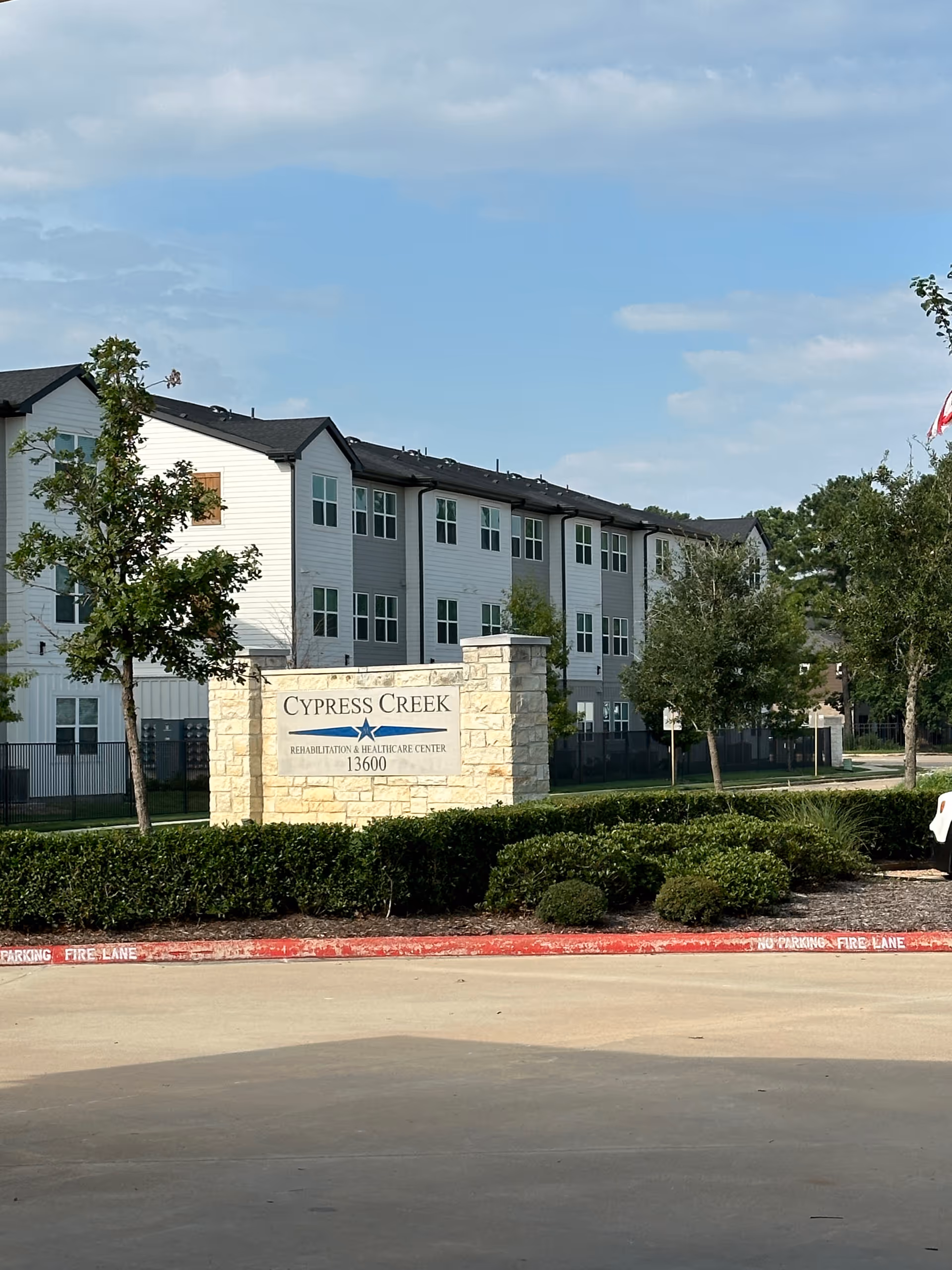 Exterior view of Cypress Creek Rehabilitation and Healthcare Center with sign and manicured landscaping.