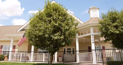 Front exterior view of Brookdale Fort Collins Assisted Living with trees and porch.
