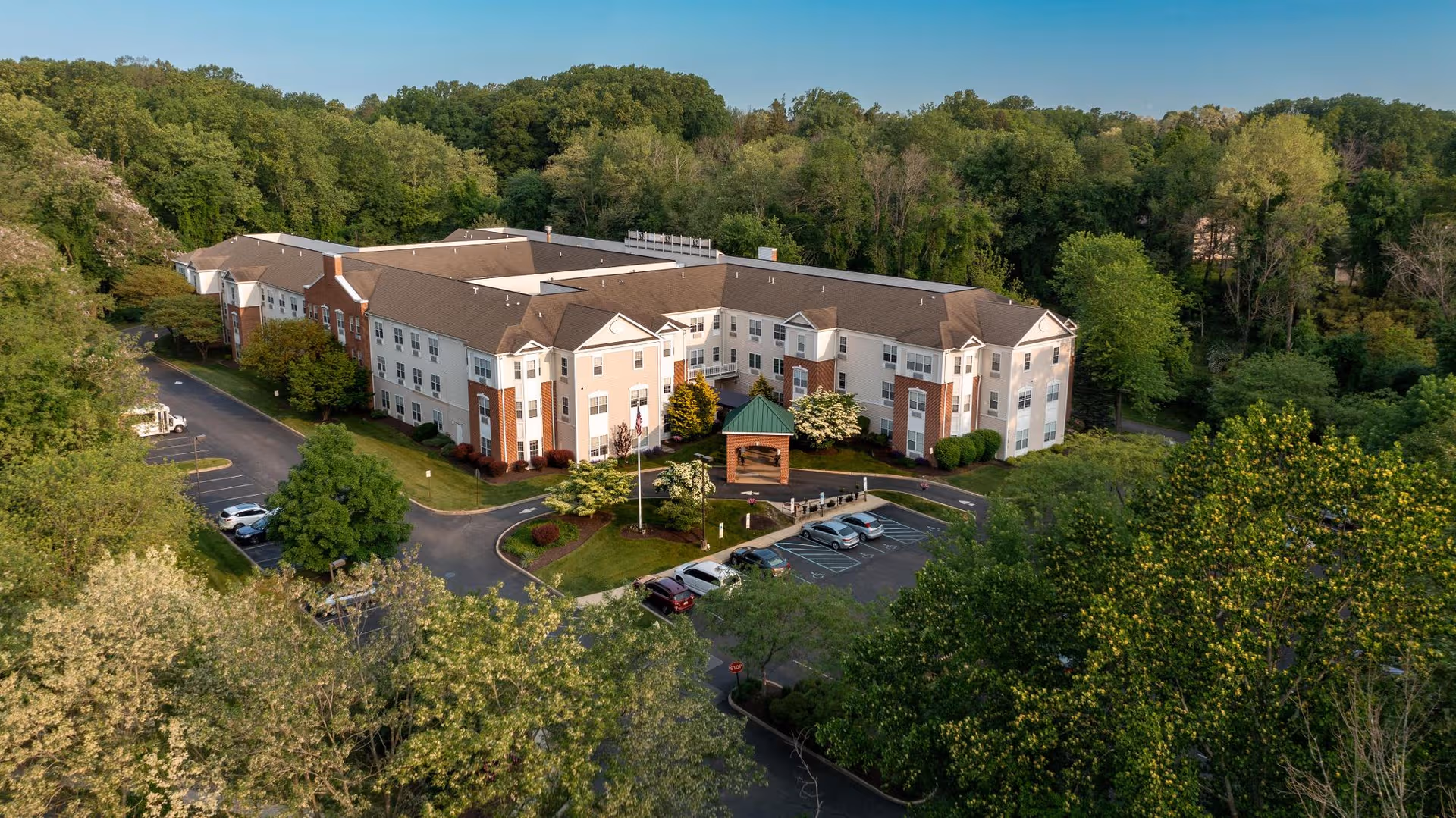 A large multi-wing senior living facility surrounded by trees.