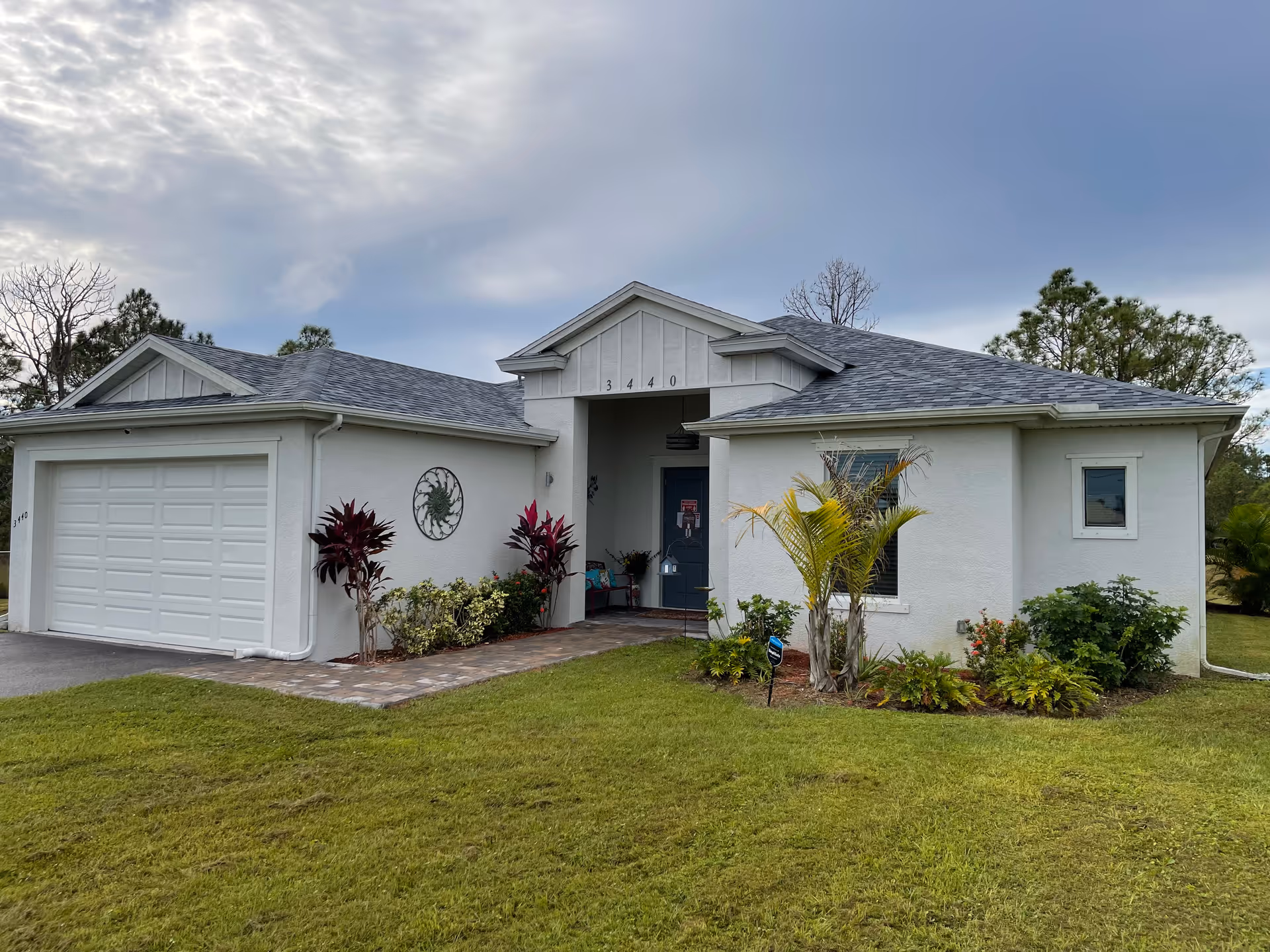 A single-story light-gray facility with a two-car garage, front entrance, and landscaped lawn.