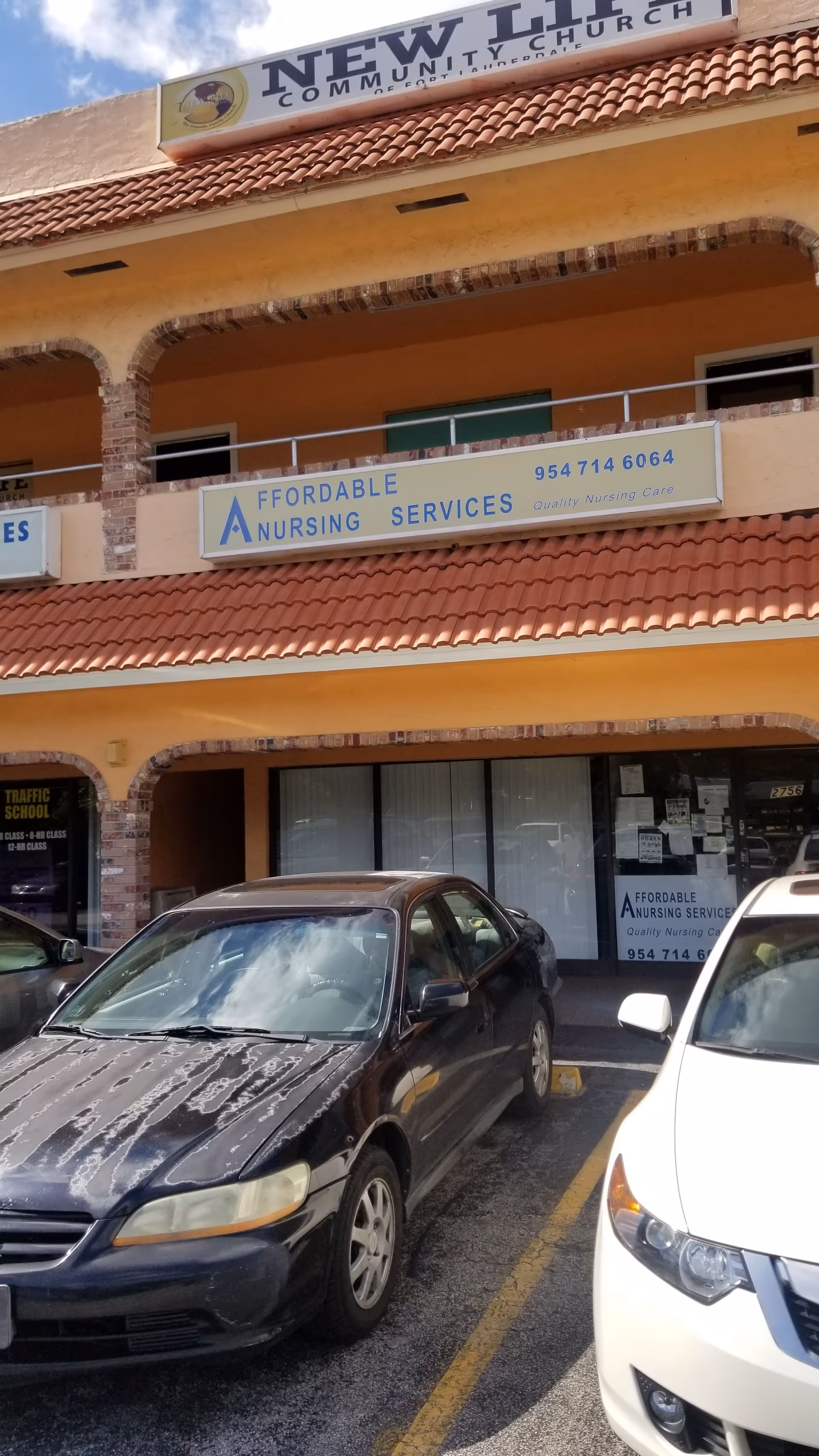 Exterior view of a strip mall-style building with Affordable Nursing Services signage and parked cars.