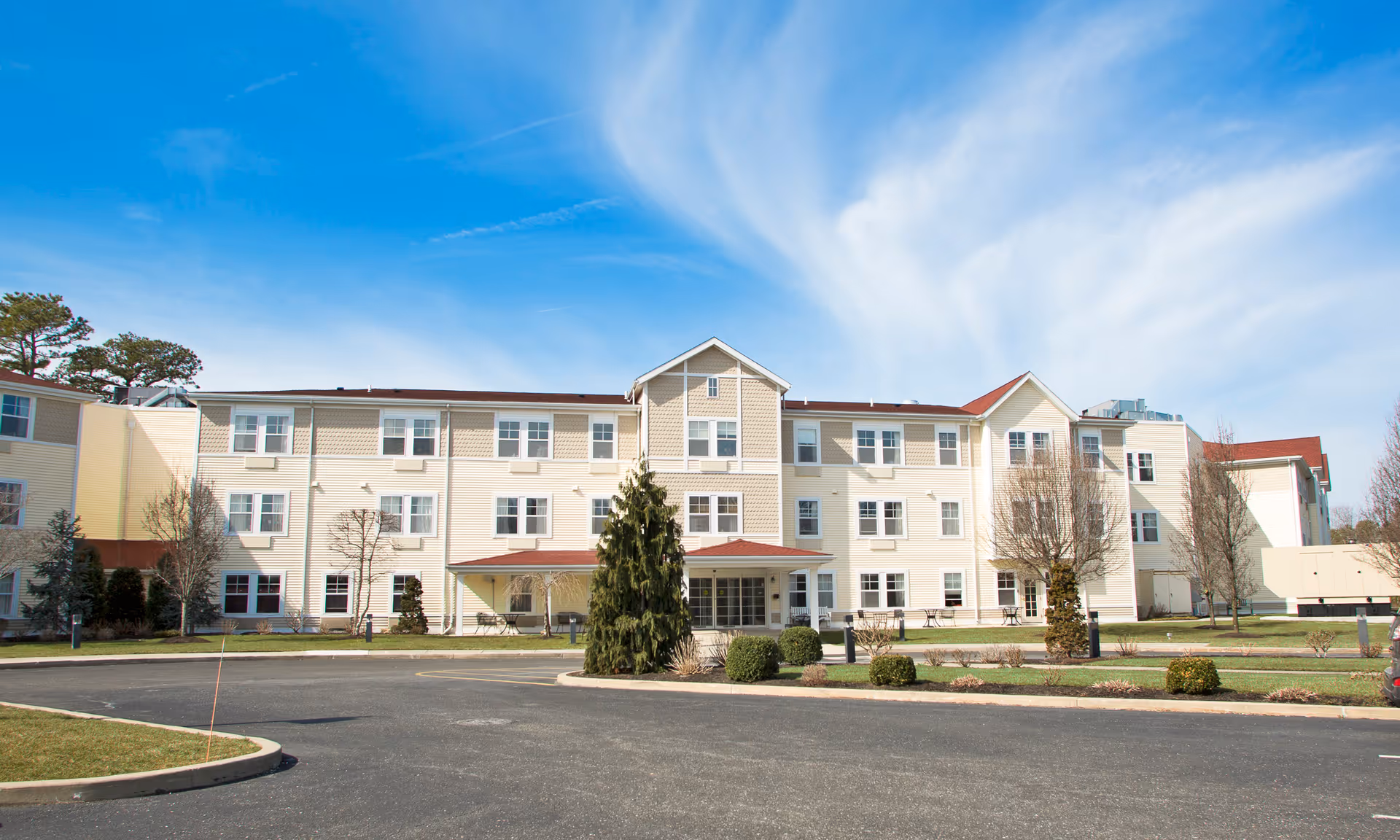 Exterior view of Brookdale Cape May building, entrance, landscaping, and surrounding parking.