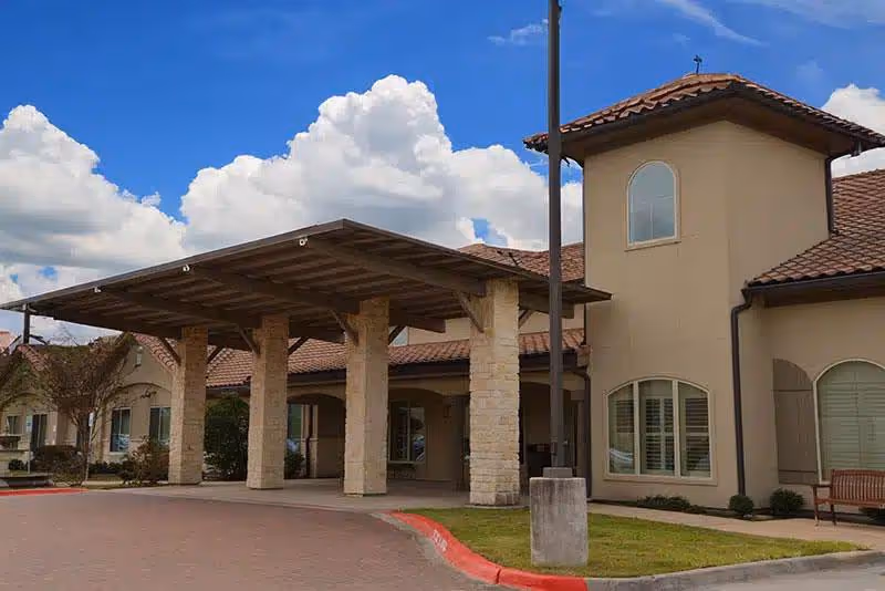 Exterior view of The Medical Resort at Pearland with a covered entrance and arched windows.