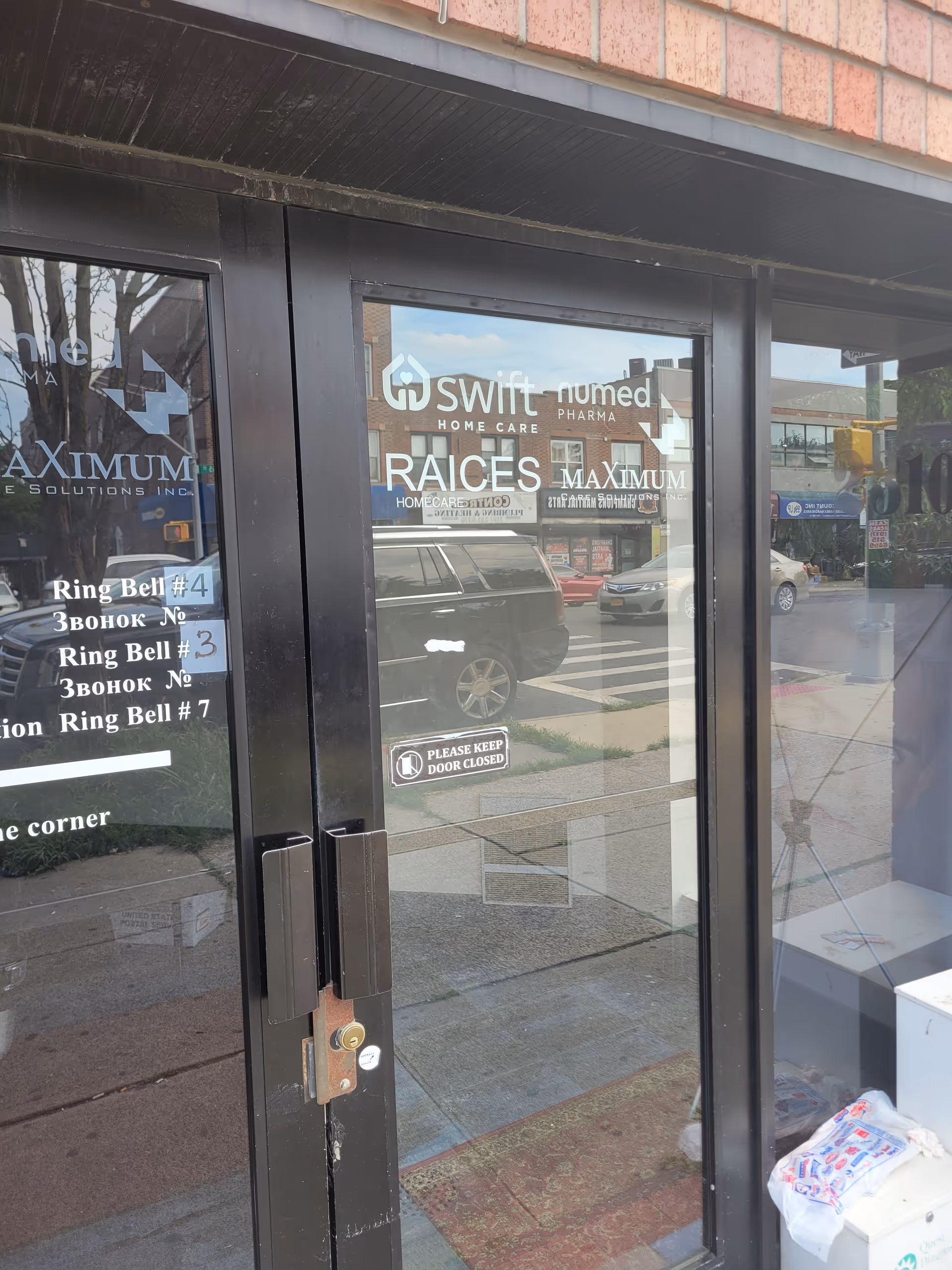 Glass storefront doors with Raices Home Care Inc signage and street reflections.