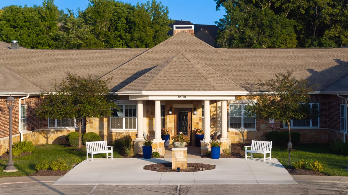 Exterior view of Silverado Overland Park Memory Care Community entrance with pillars and benches