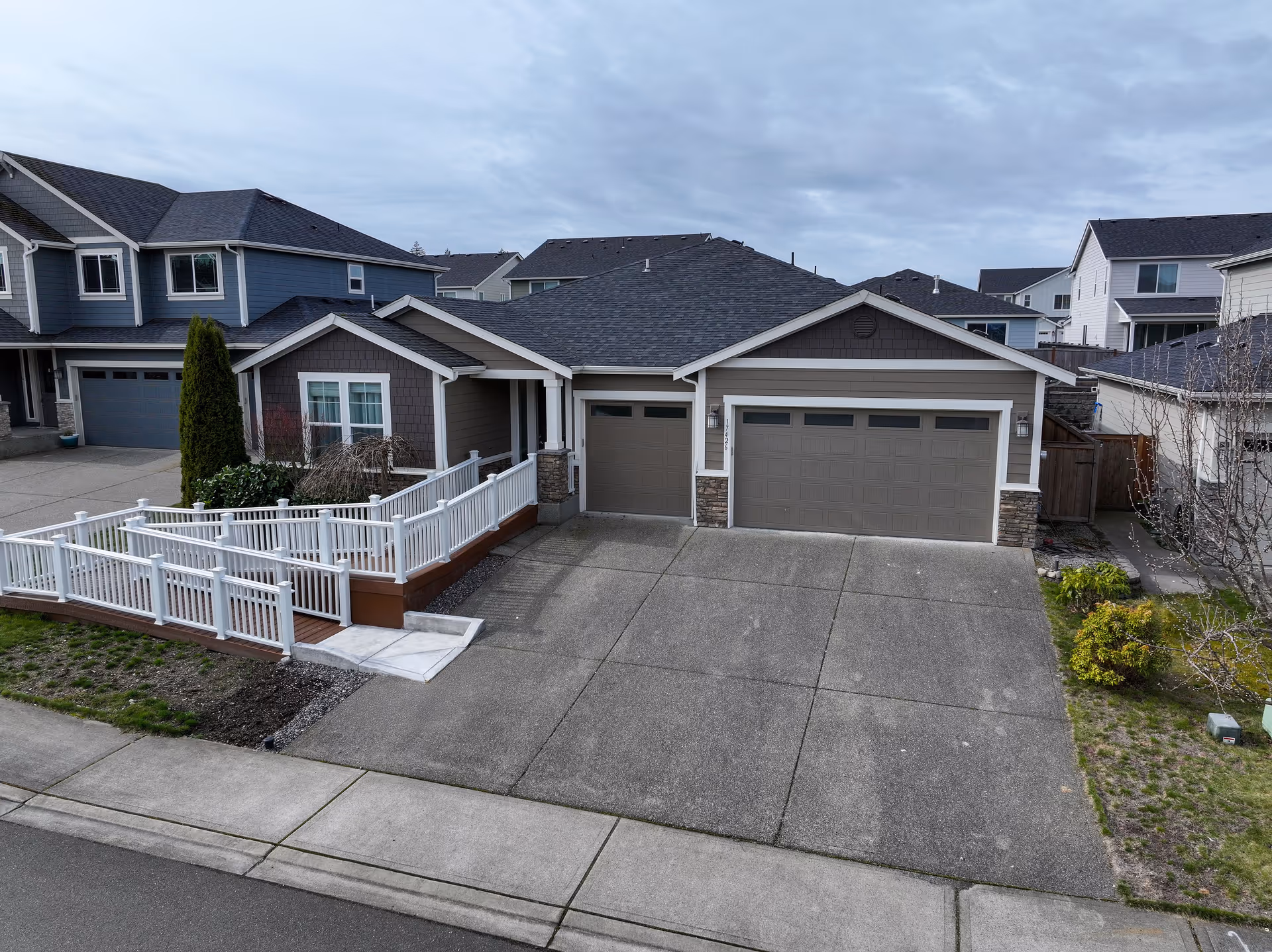 Front exterior of a suburban home with a multi-car garage and ramped entrance.
