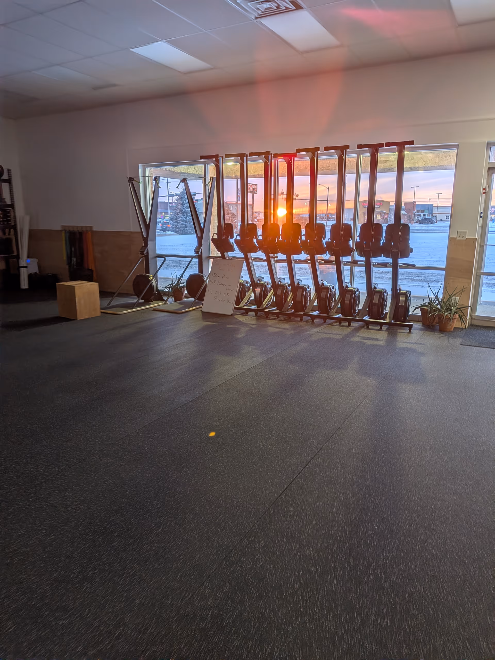 Row of stationary bikes in Rech Physio rehab gym by large windows.