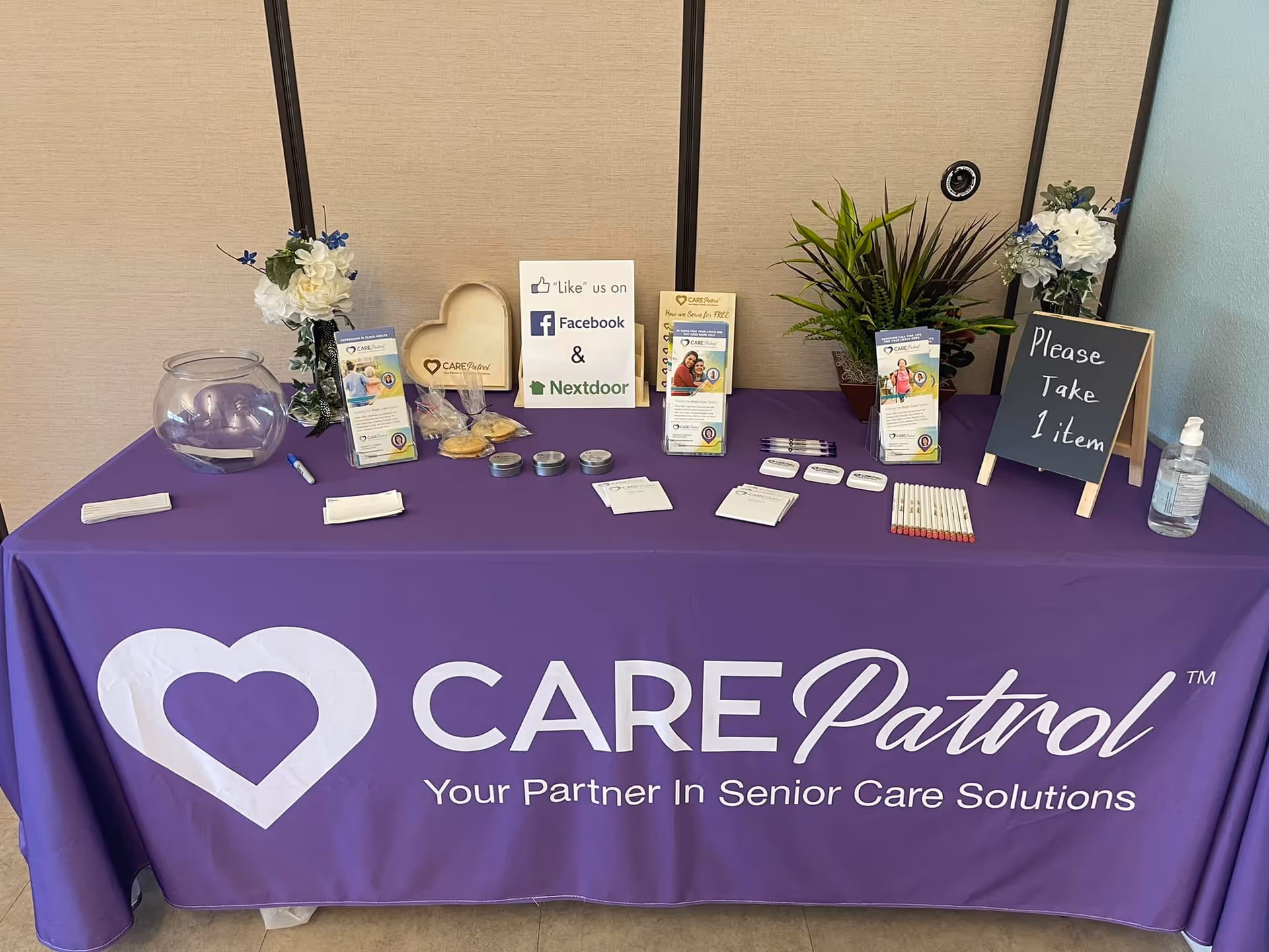 Purple CarePatrol information table with brochures and signs in a facility lobby