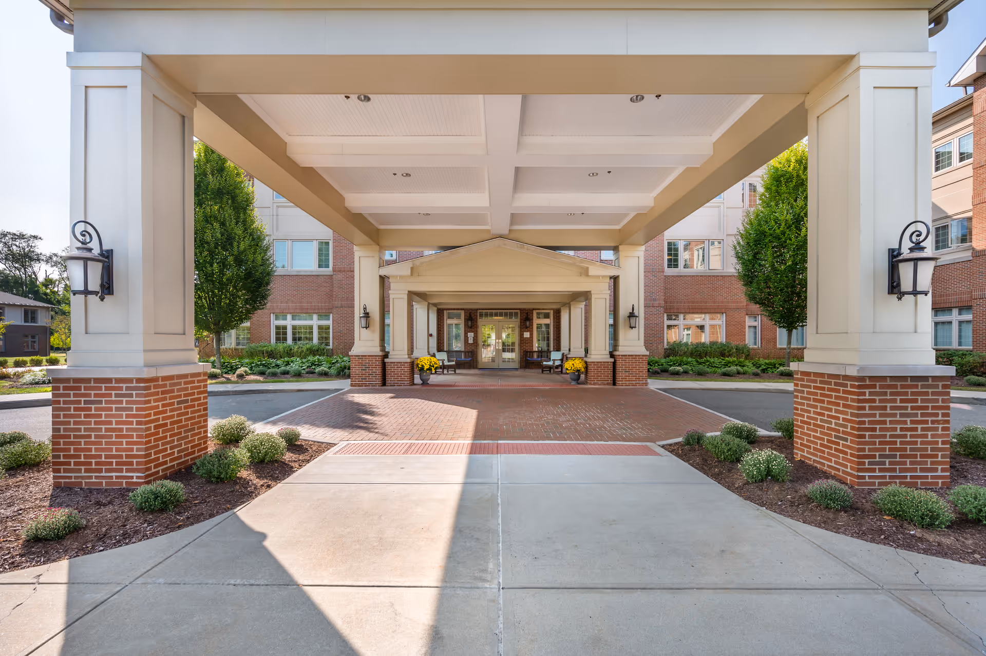 Covered entrance of Brookdale Chatfield senior living with brick columns and landscaping.