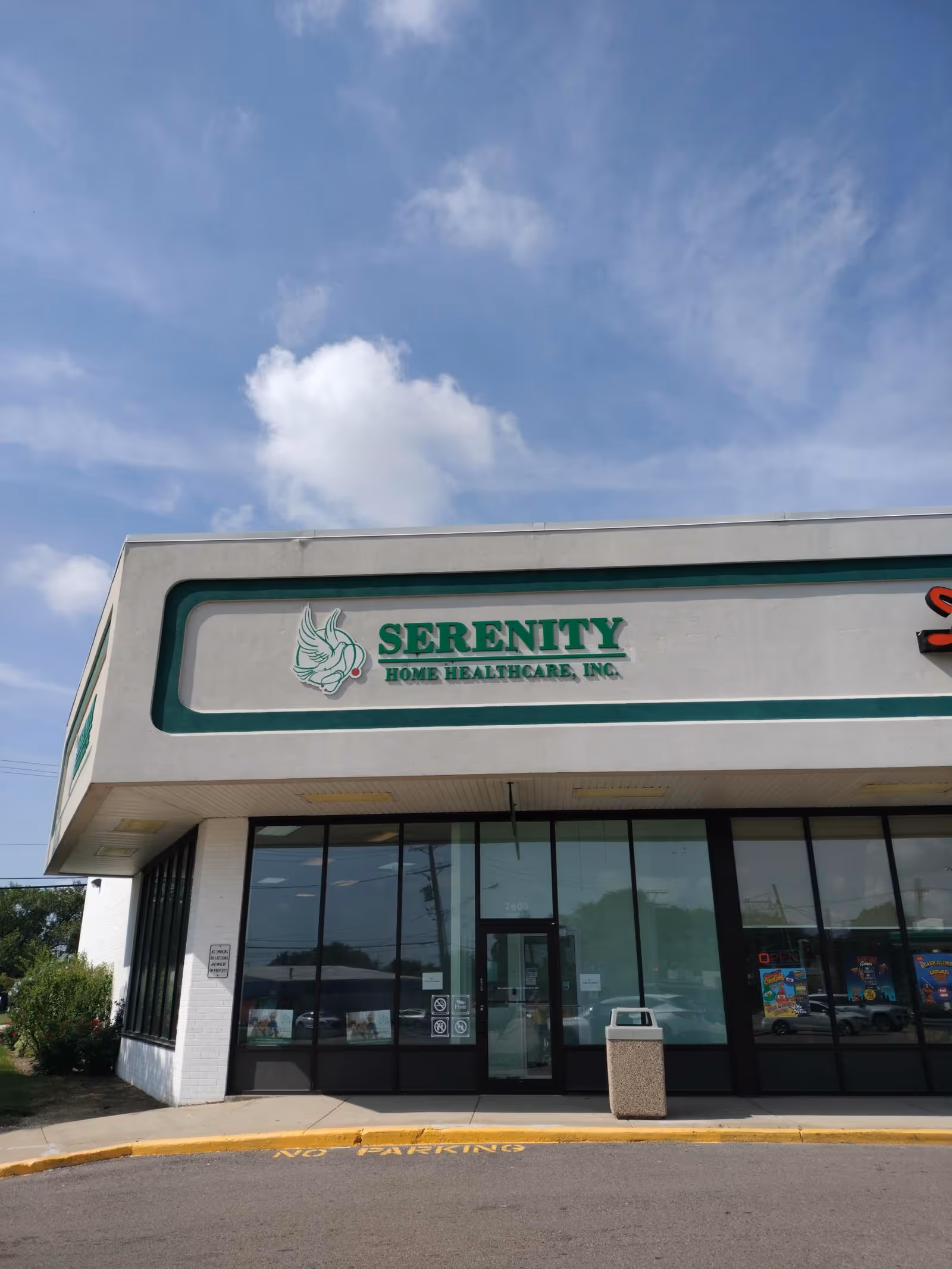 Front view of Serenity Home Healthcare building with green signage and glass doors.