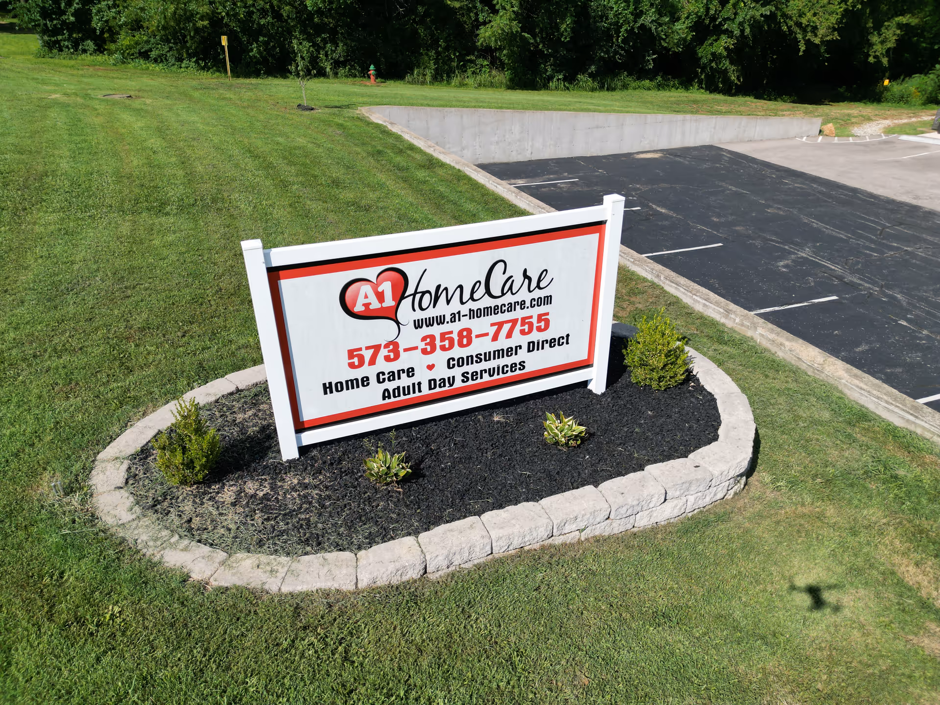A1 Home Care sign surrounded by a landscaped bed and a parking lot.