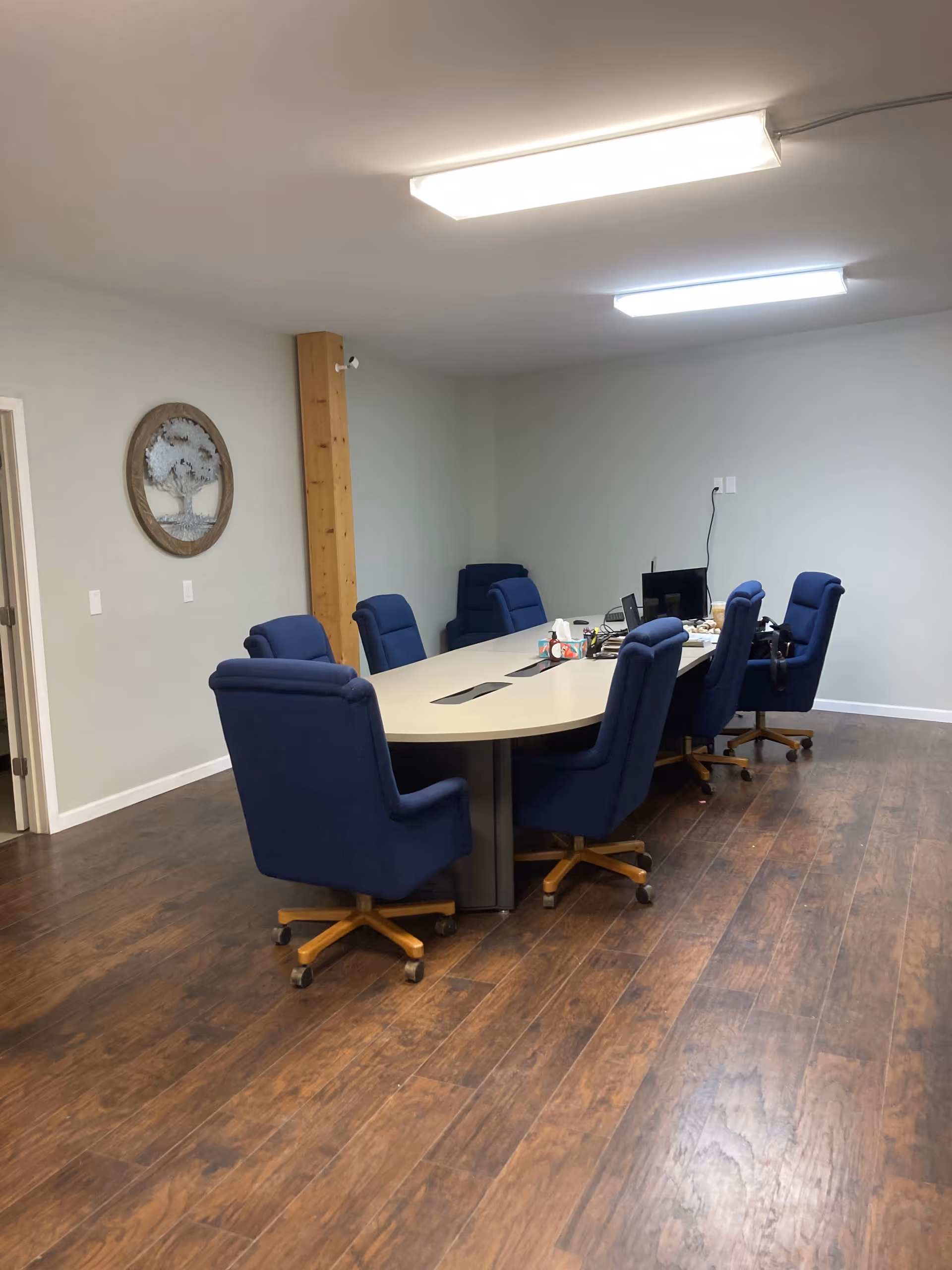 A conference room in a senior facility featuring a large oval table and blue office chairs.