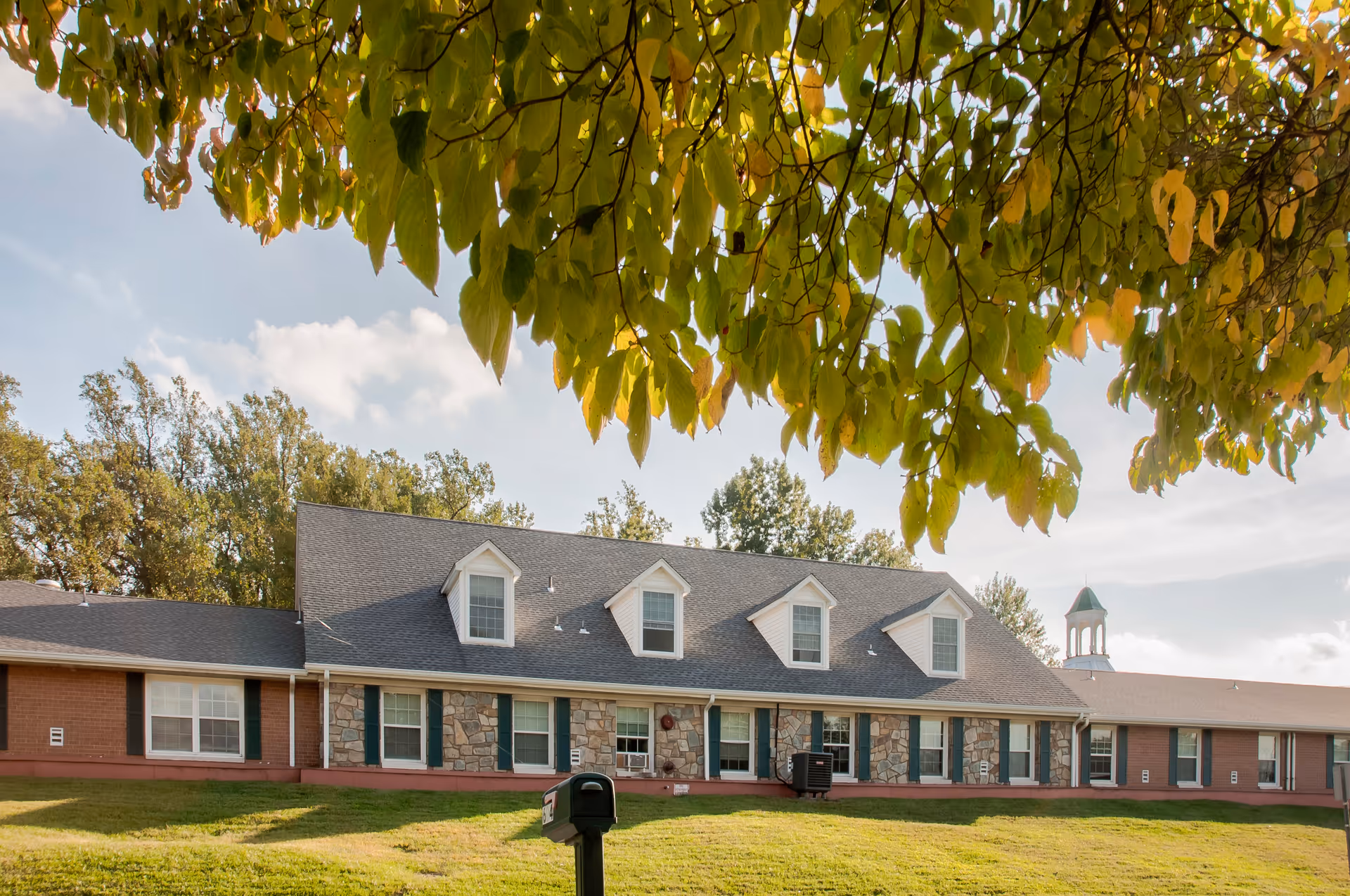 Exterior view of Genesis Springbrook senior living facility showing a single-story building with dormer windows.