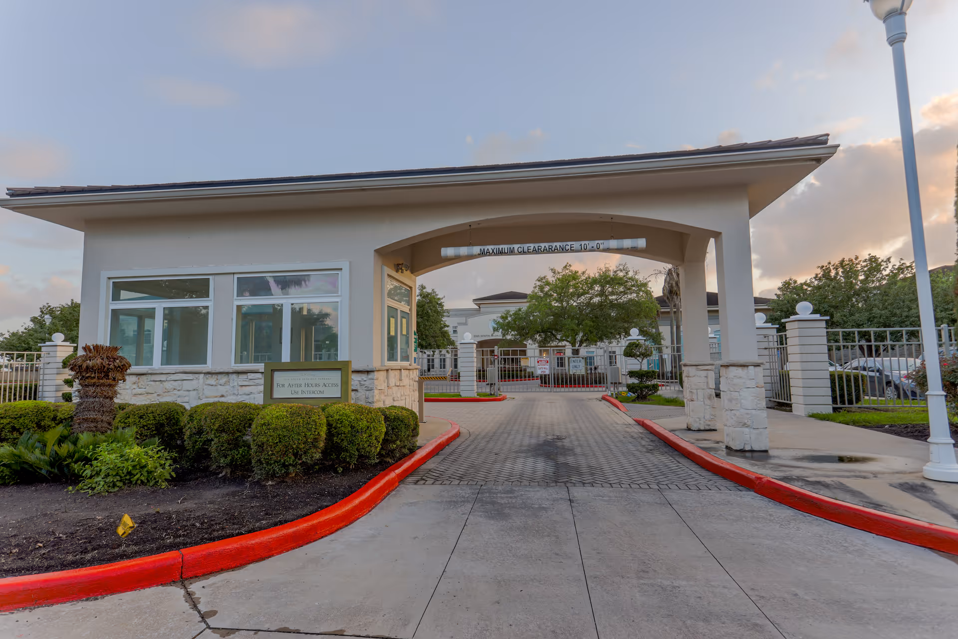 Front entrance of a senior living facility with a covered driveway and decorative archway.
