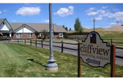 Outdoor view of Cliffview Assisted Living Center showing a sign, lamppost, fence, and building.