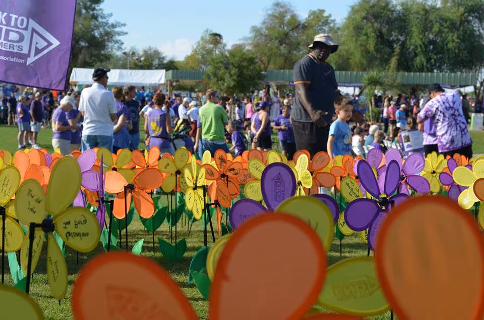 Outdoor event at a senior care facility with colorful pinwheels in foreground.