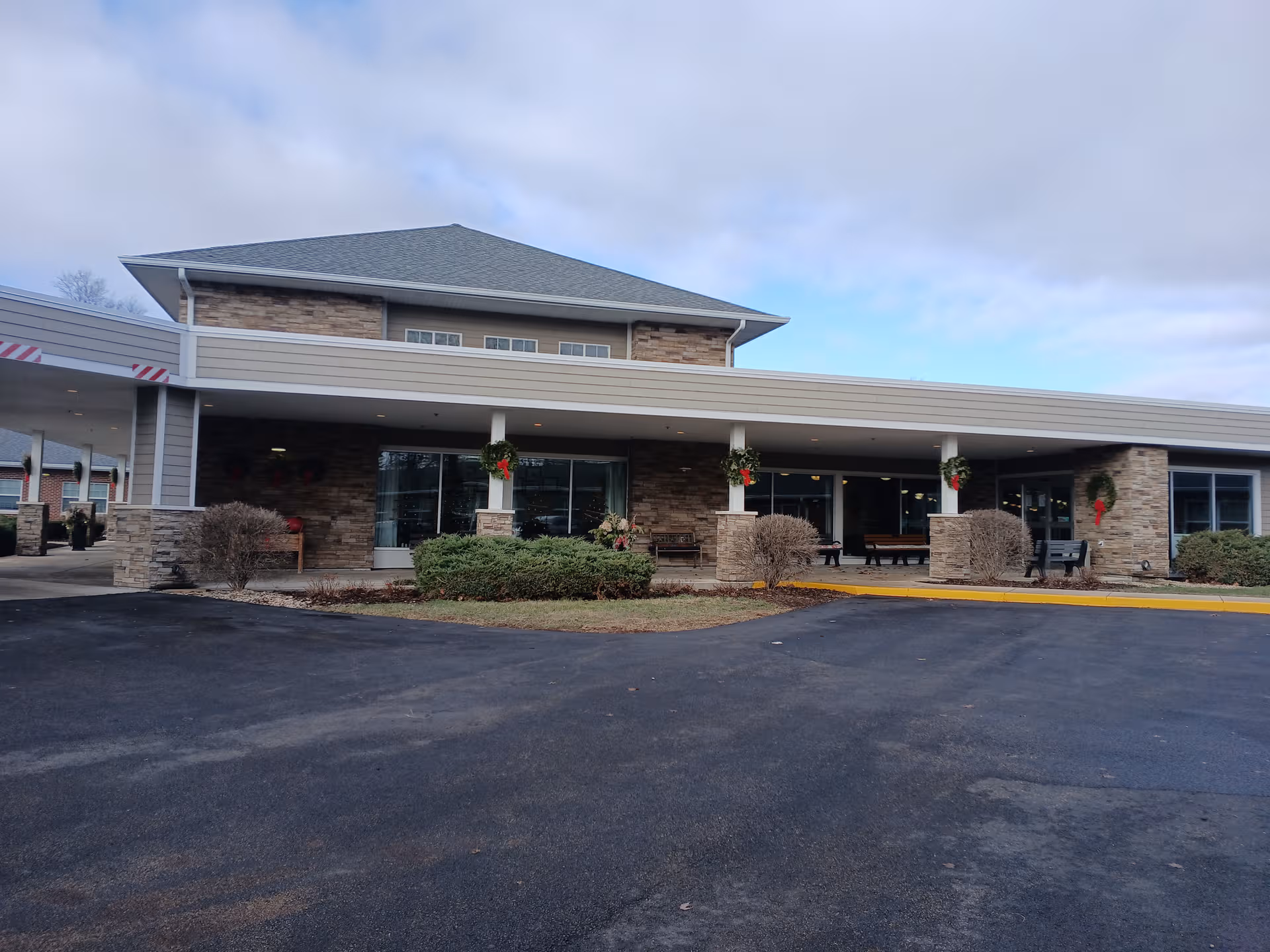 Exterior view of Resthave Care & Rehabilitation front entrance with stone columns and holiday wreaths.
