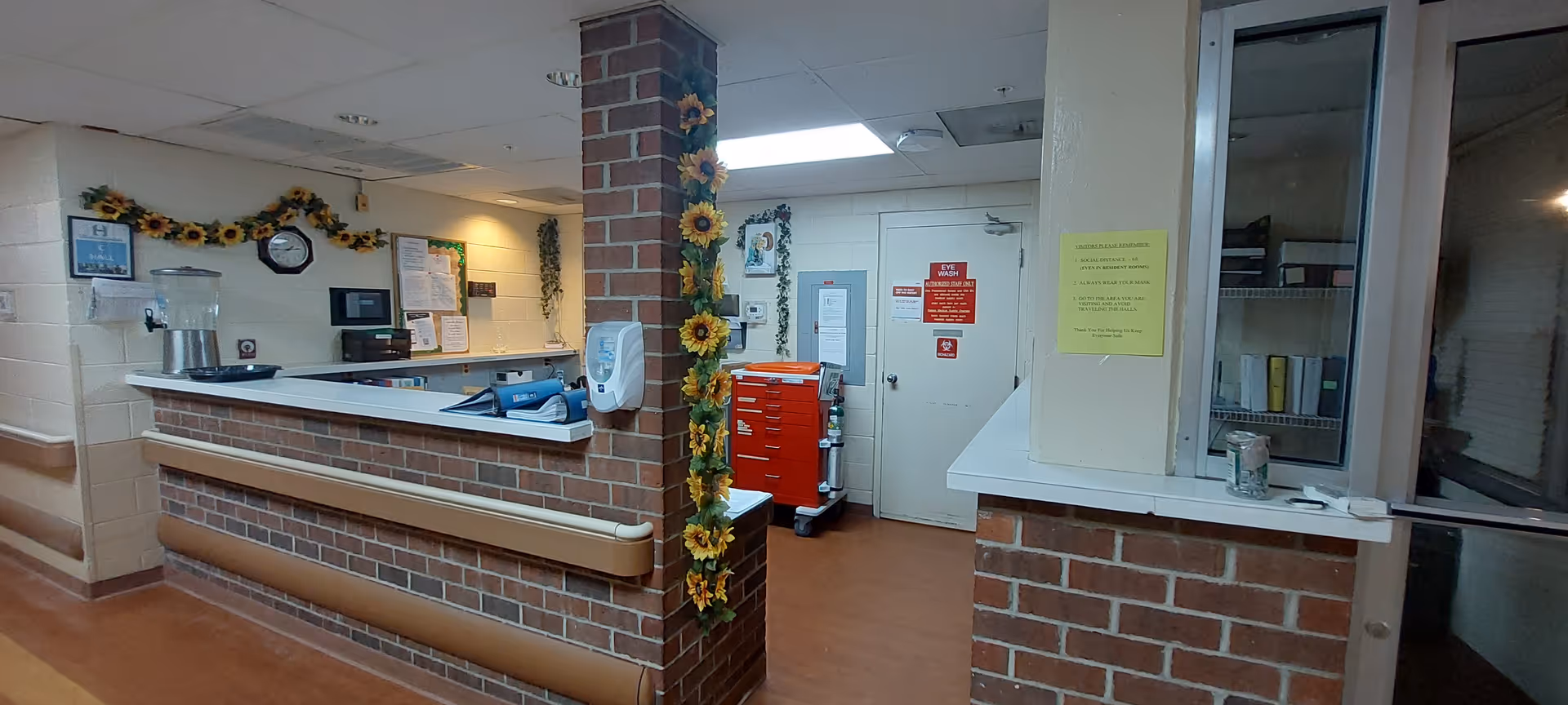 Indoor reception area at Highland House with brick counter and sunflower garlands.