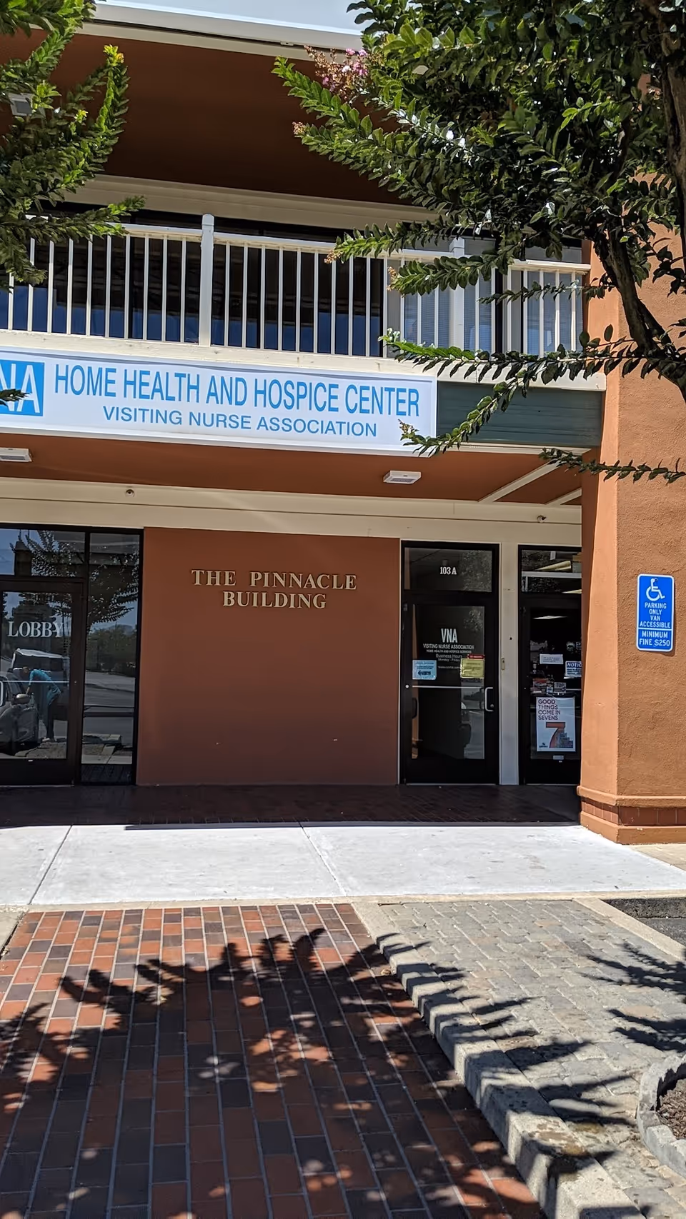 Front of The Pinnacle Building featuring Visiting Nurse Association entrance signs.