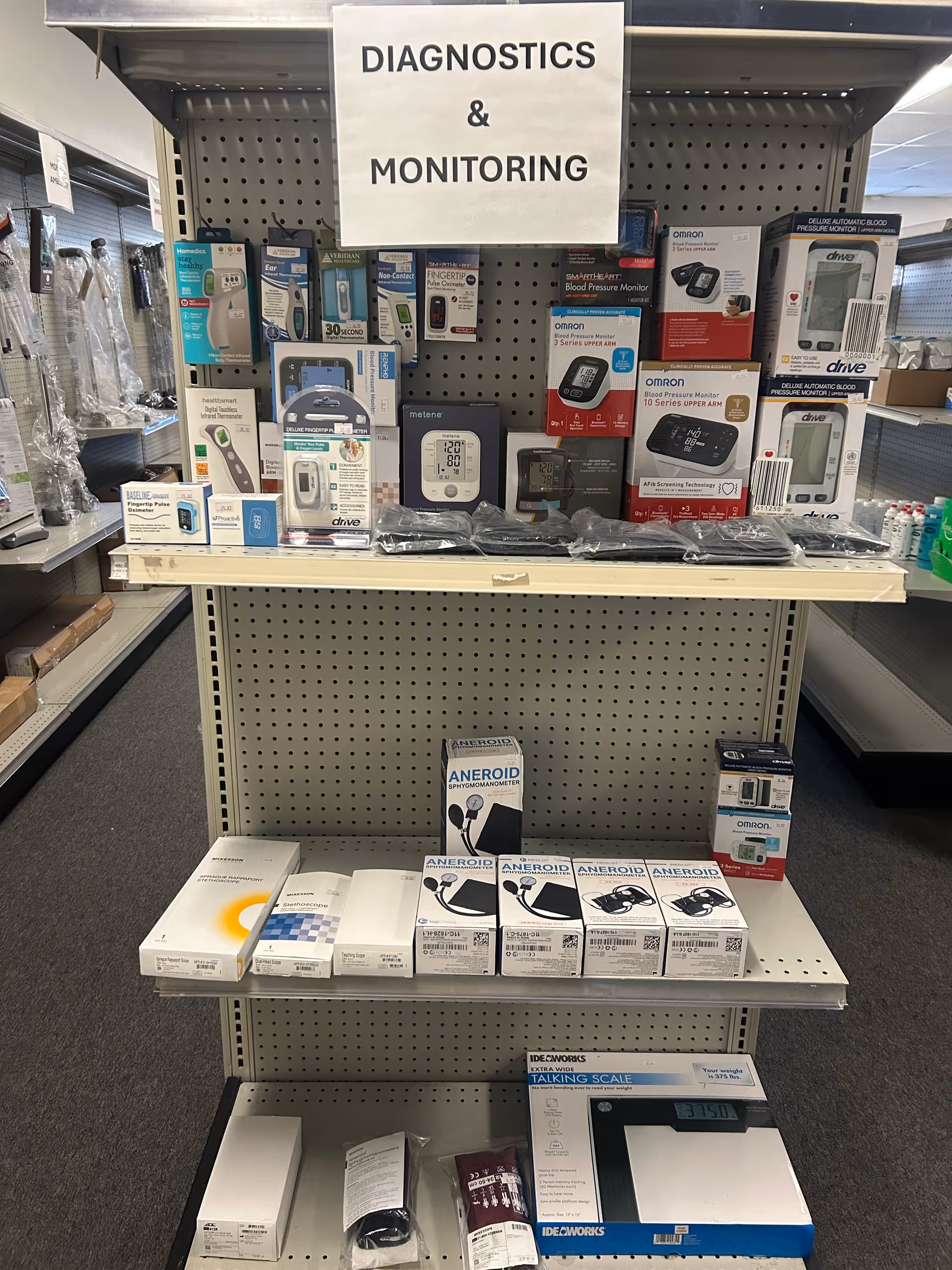 Display shelf labeled Diagnostics & Monitoring with various blood pressure devices and related boxes.