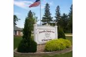 Front view of Riceville Family Care and Therapy Center sign with landscaping and flag.