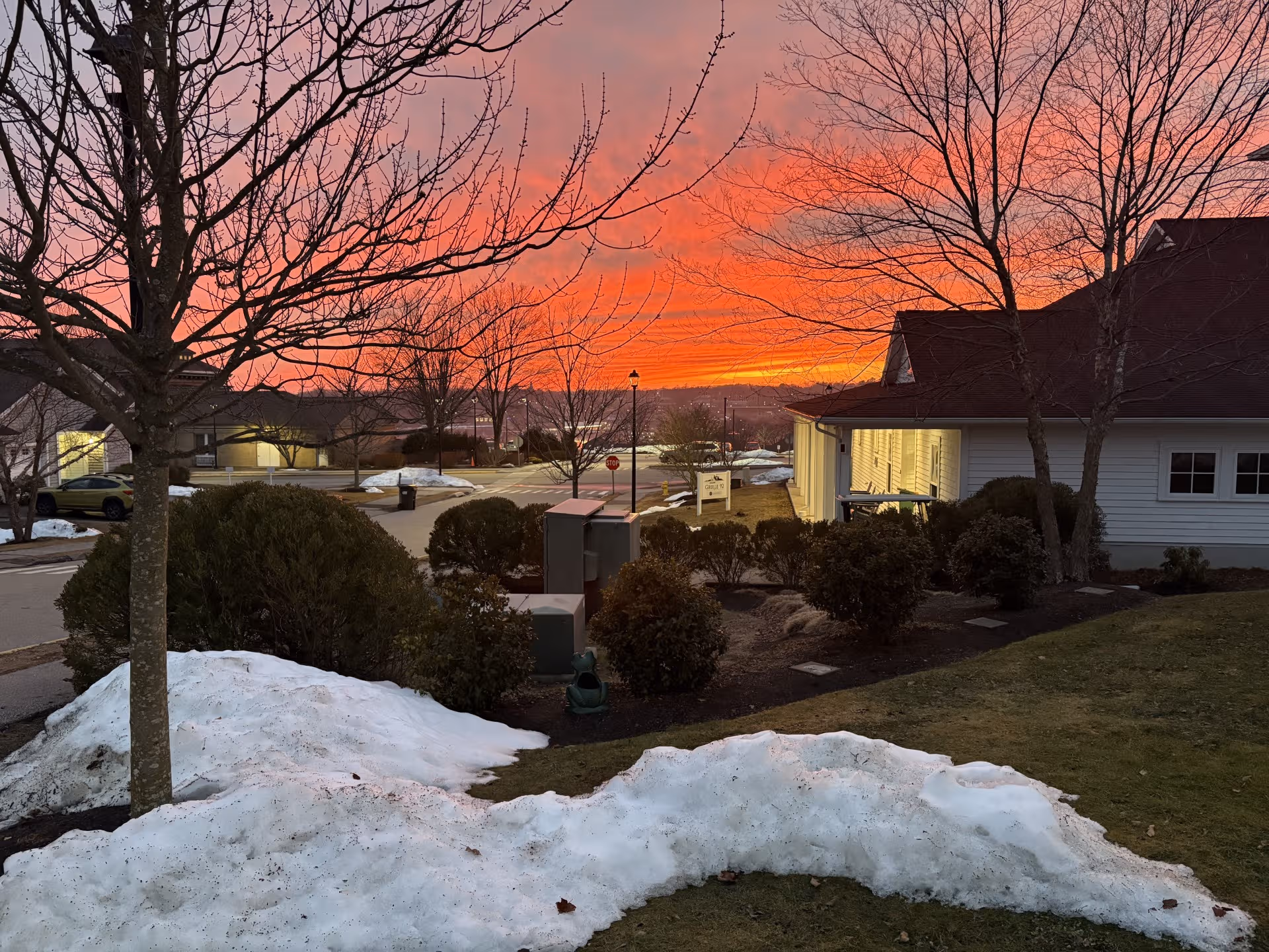 Sunset sky over the exterior of a Fairview senior living facility with snow.