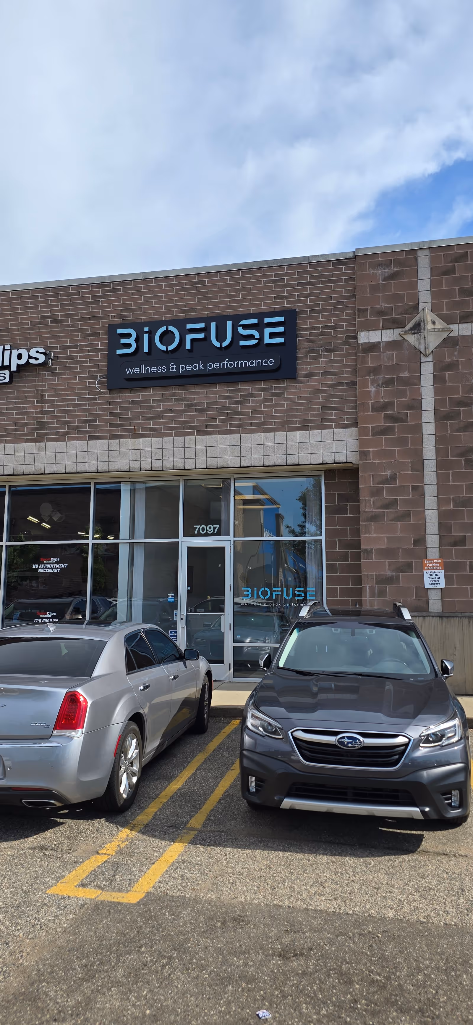 Exterior view of Biofuse storefront with signage and parked cars.