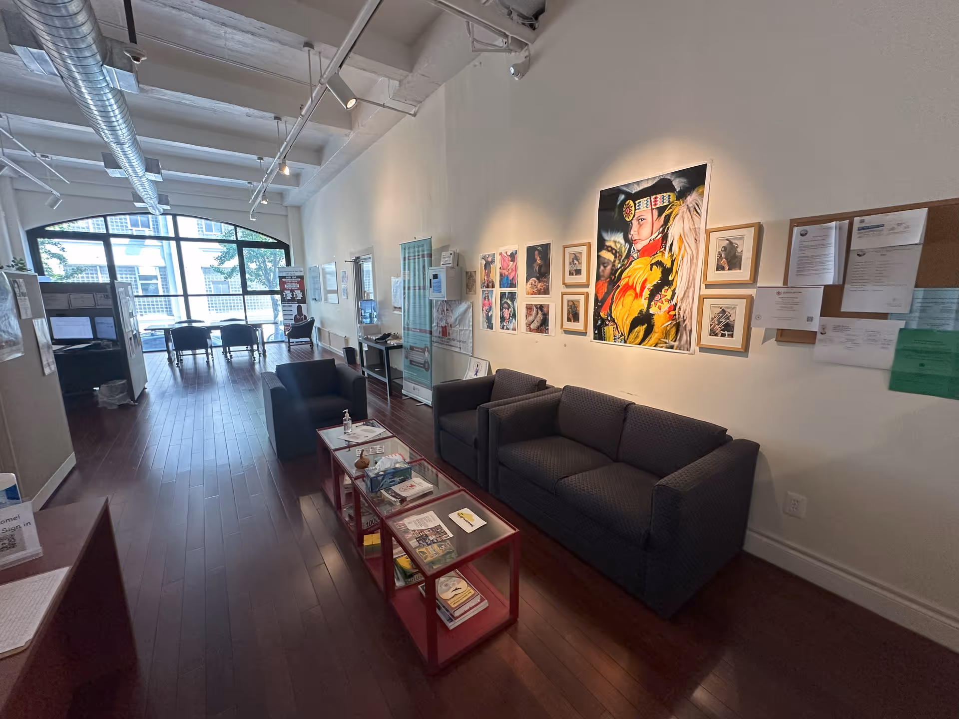 A modern, spacious waiting area with sofas, magazines, and wall art.