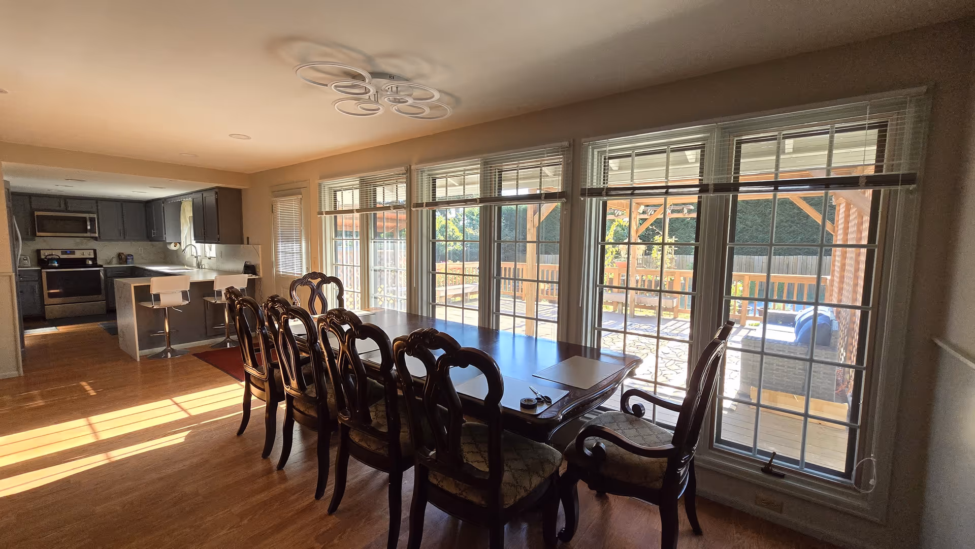 A spacious dining area with a long table and elegant chairs near large windows.