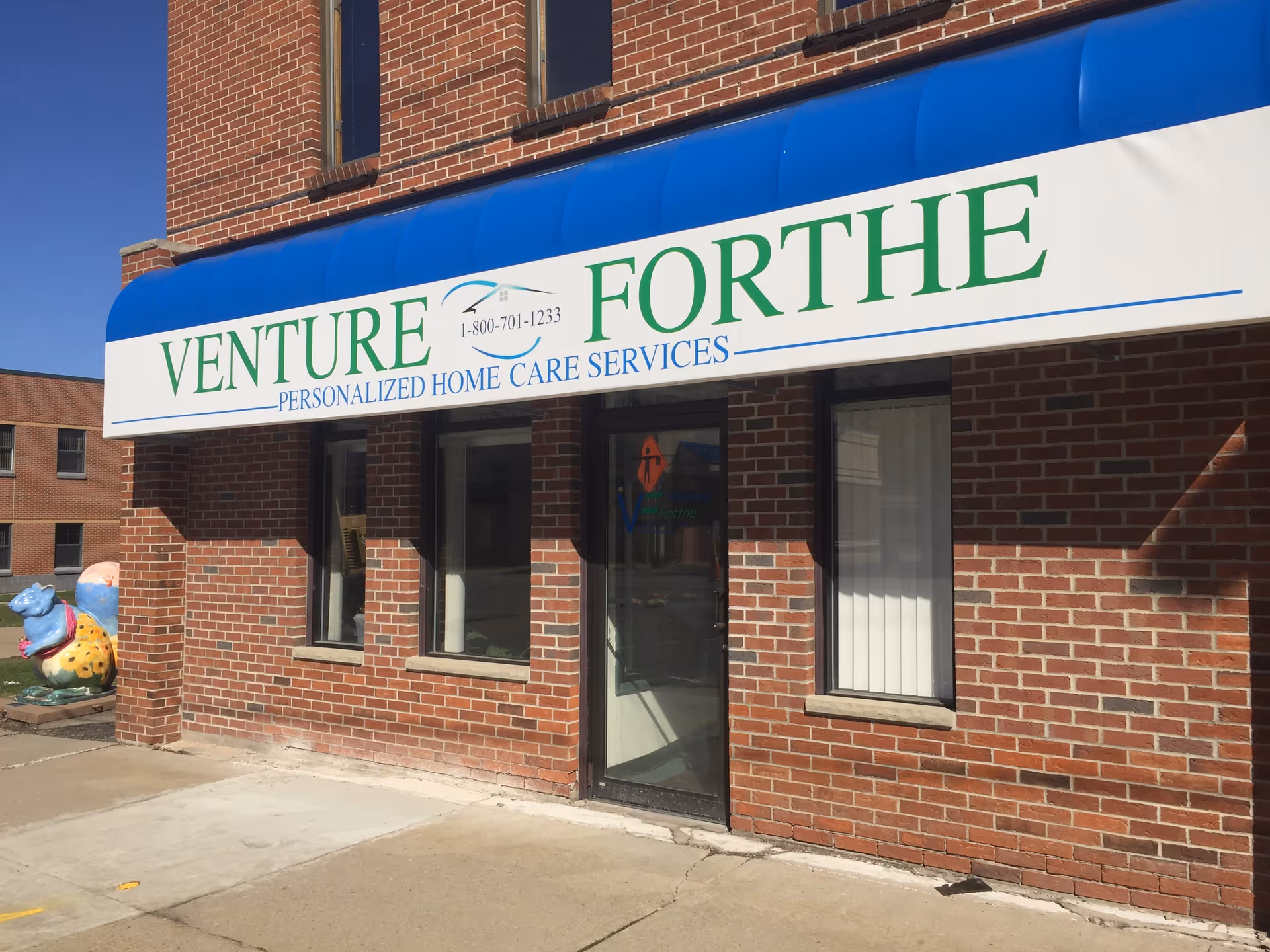 Brick storefront with a large Venture Forthe sign above the entrance.