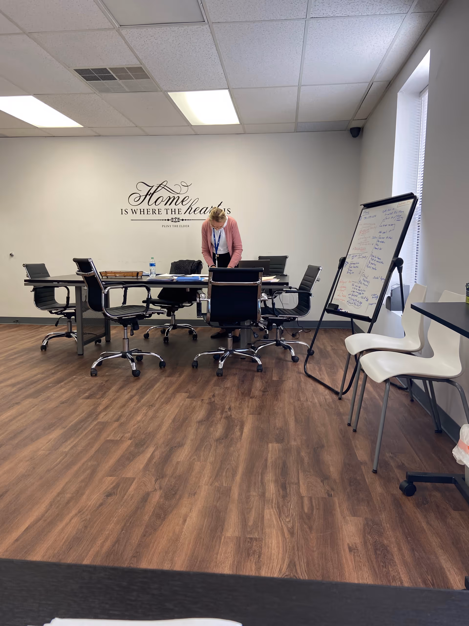 A conference room with a person standing at a long table beneath wall art.