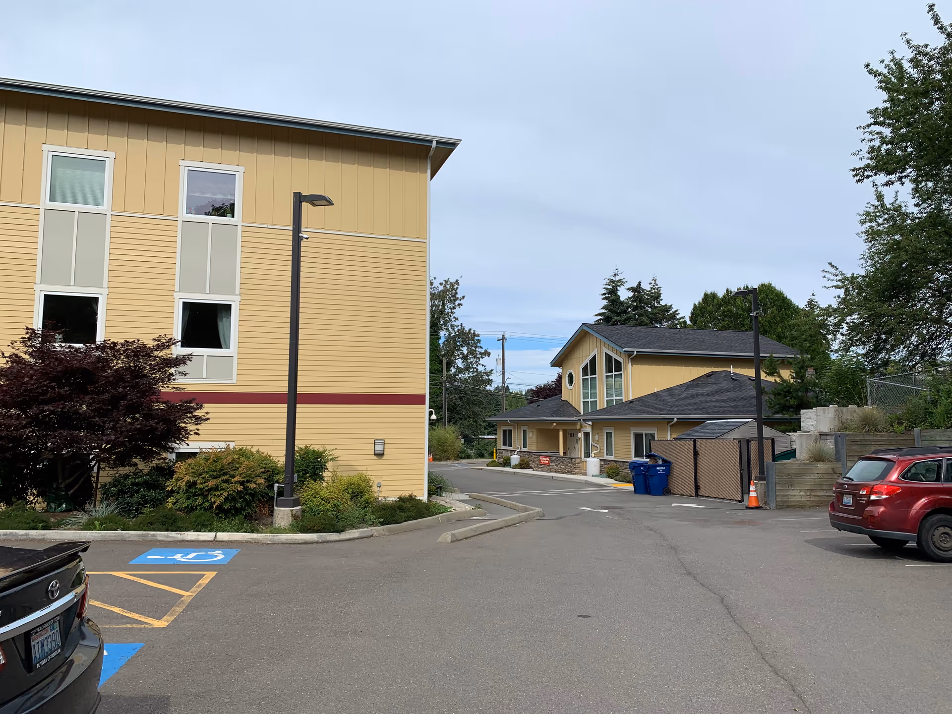 Exterior view of Kin On senior living facility with parking lot and beige building.