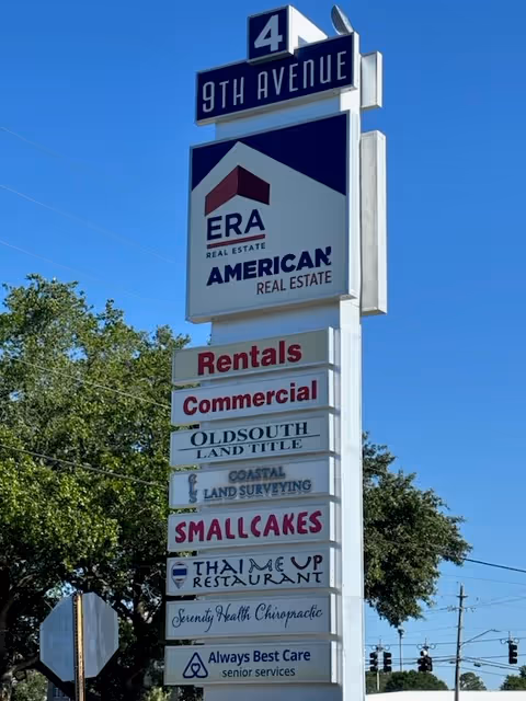 Tall outdoor signpost with multiple business signs, including Always Best Care Senior Services, along street.
