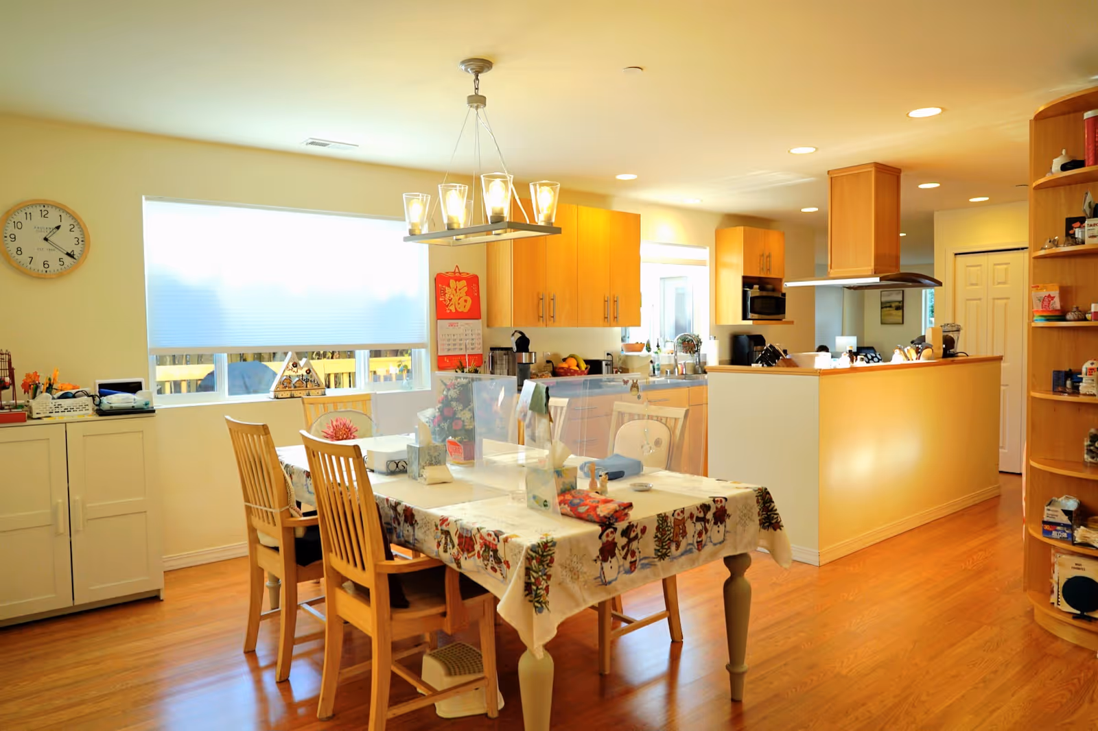 Bright open kitchen and dining area with a table, chairs, and wooden cabinets.