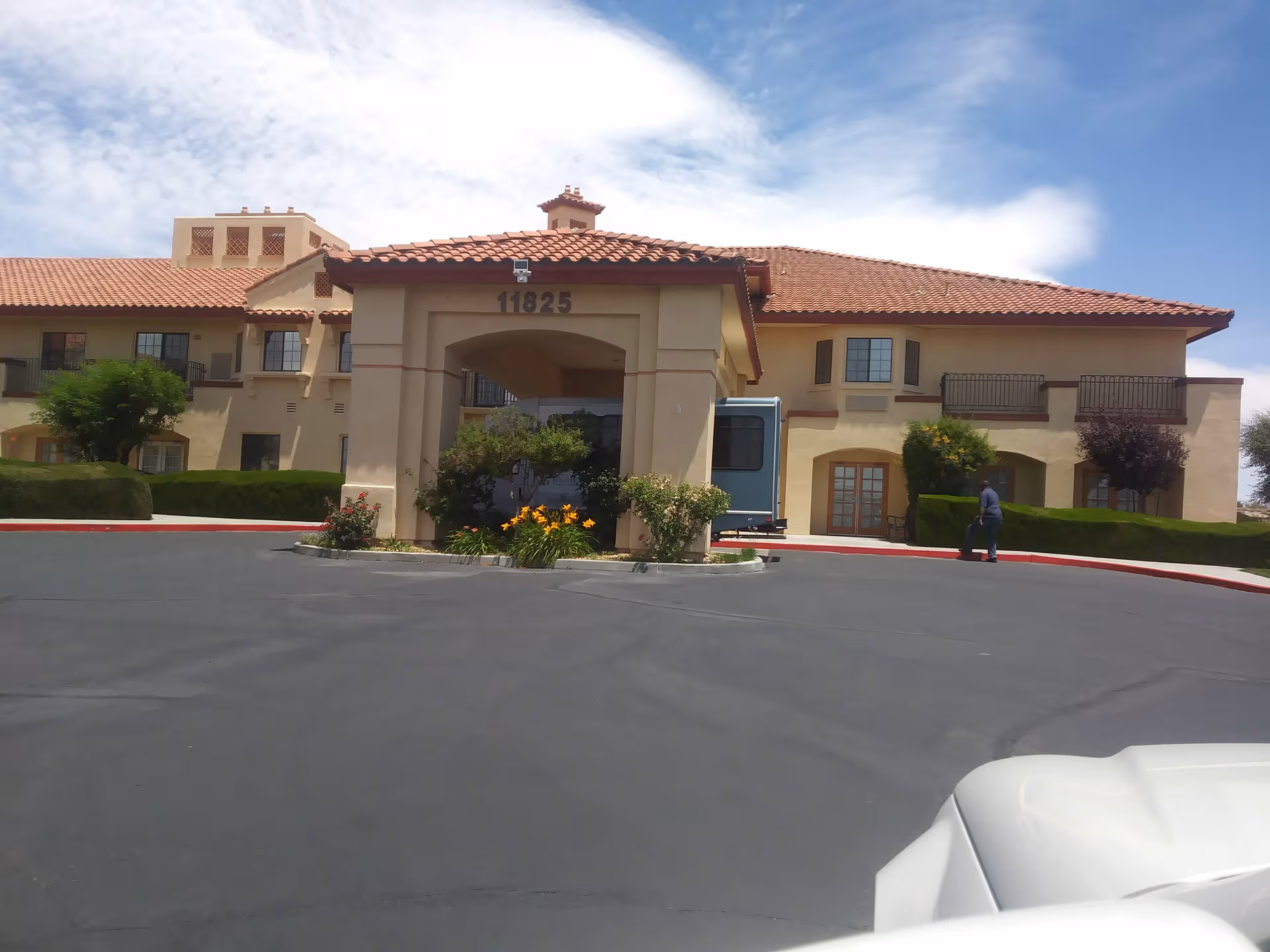 Exterior view of Whispering Winds of Apple Valley, with entrance and landscaping.