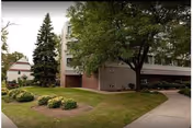Exterior view of Chelsea Place Care Center building with landscaped lawn and walkway.