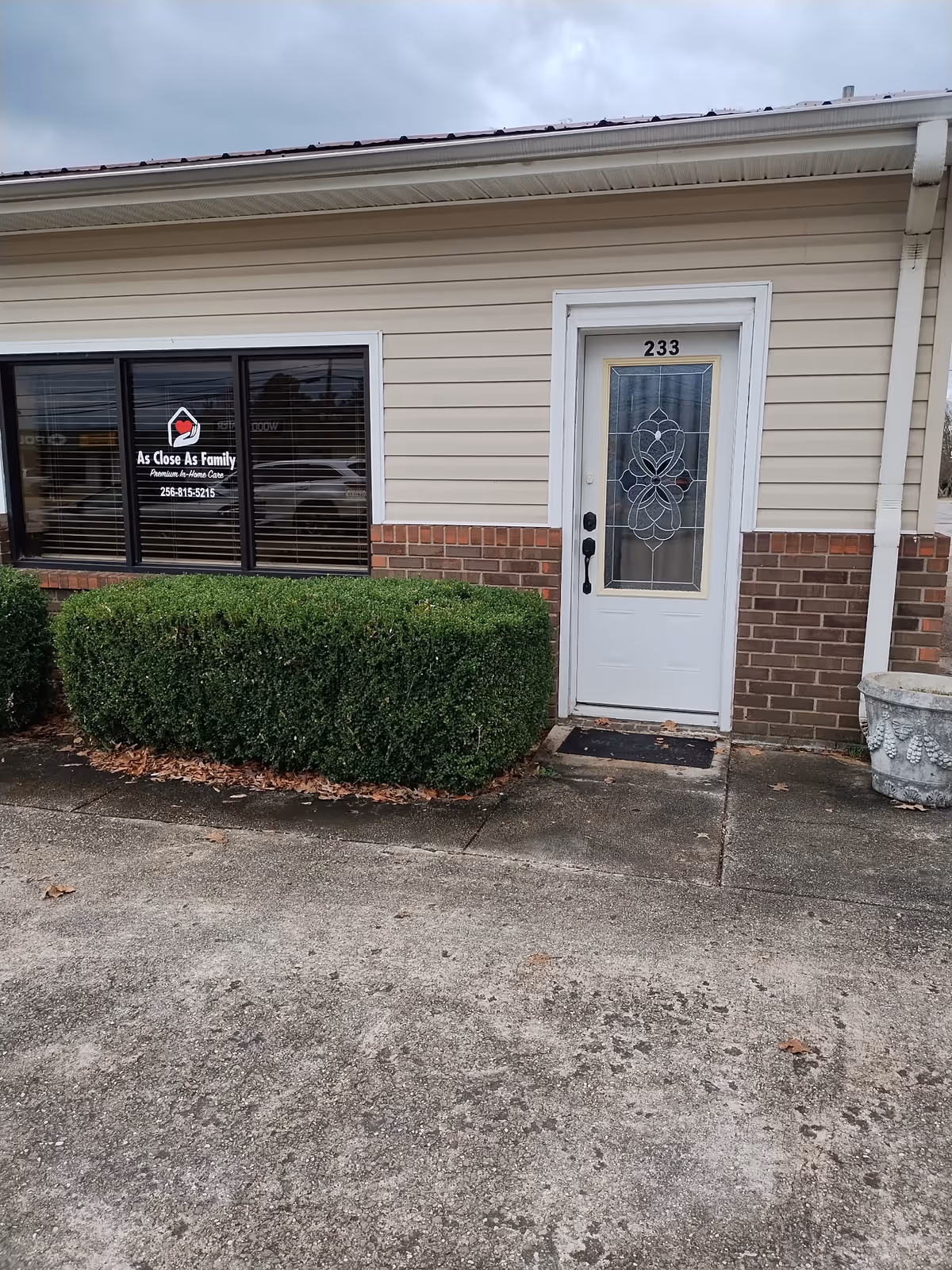 Front exterior of As Close As Family facility with window sign and decorative door.