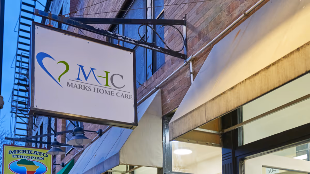 Exterior storefront with a hanging sign for Marks Home Care.