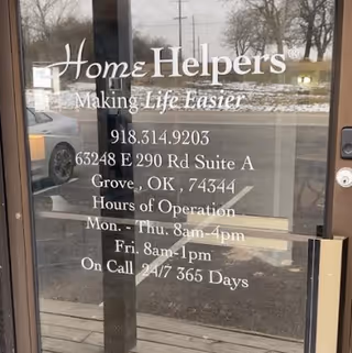 Front glass door of Home Helpers storefront, displaying slogan and contact information.