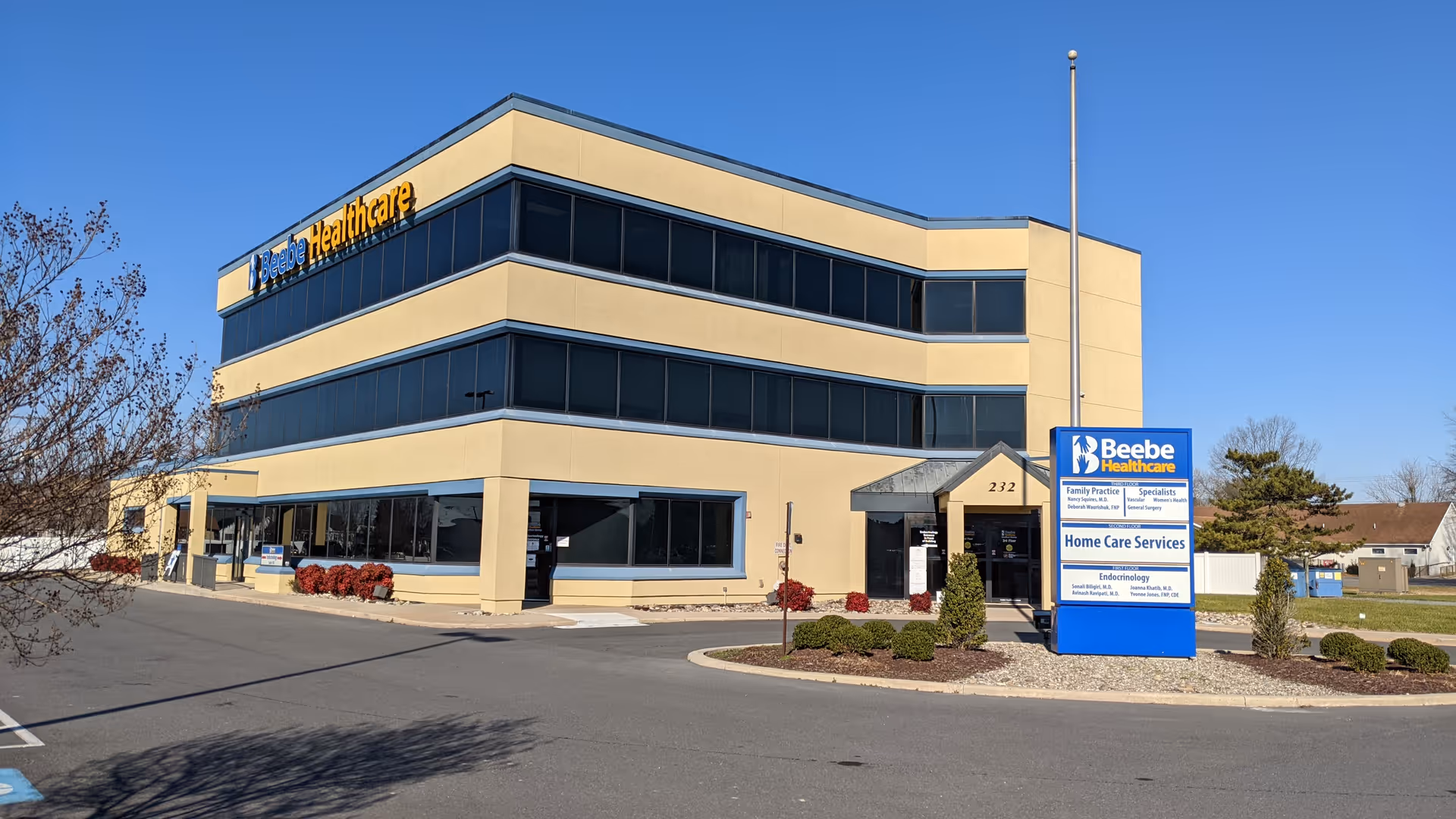 Two-story beige Beebe Healthcare building exterior with blue-tinted windows and signage.