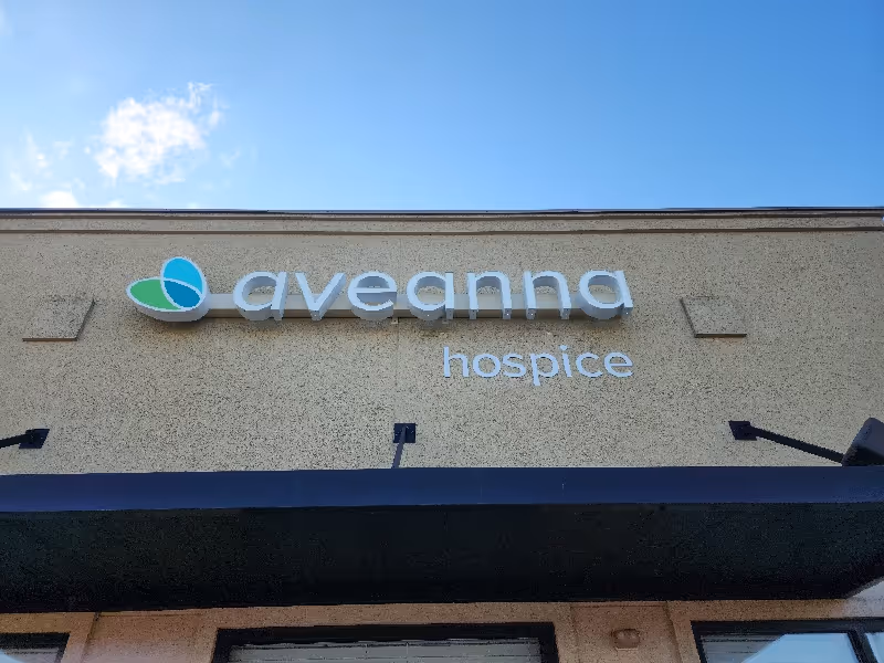 Exterior of a beige building with Aveanna Hospice sign and logo on the facade.