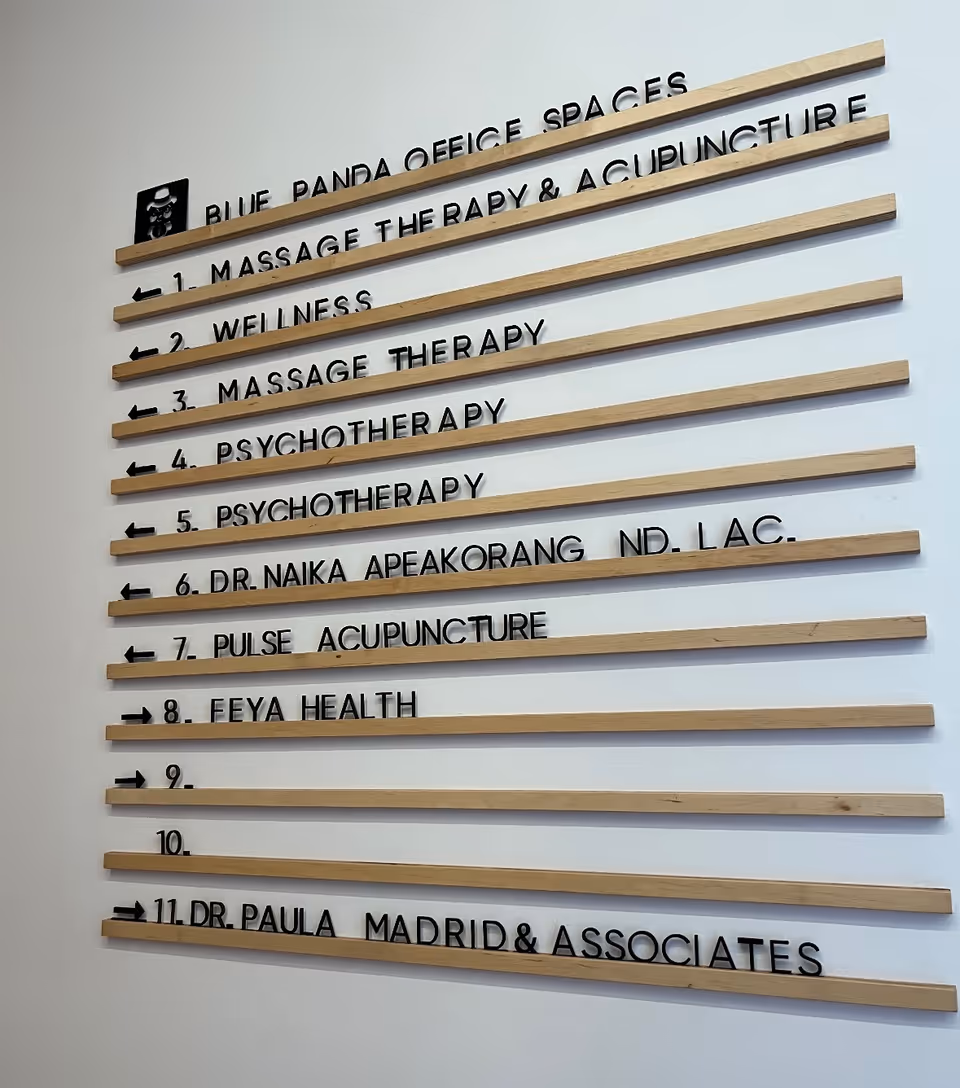 Interior wall with horizontal wooden slats forming a directory of wellness services.