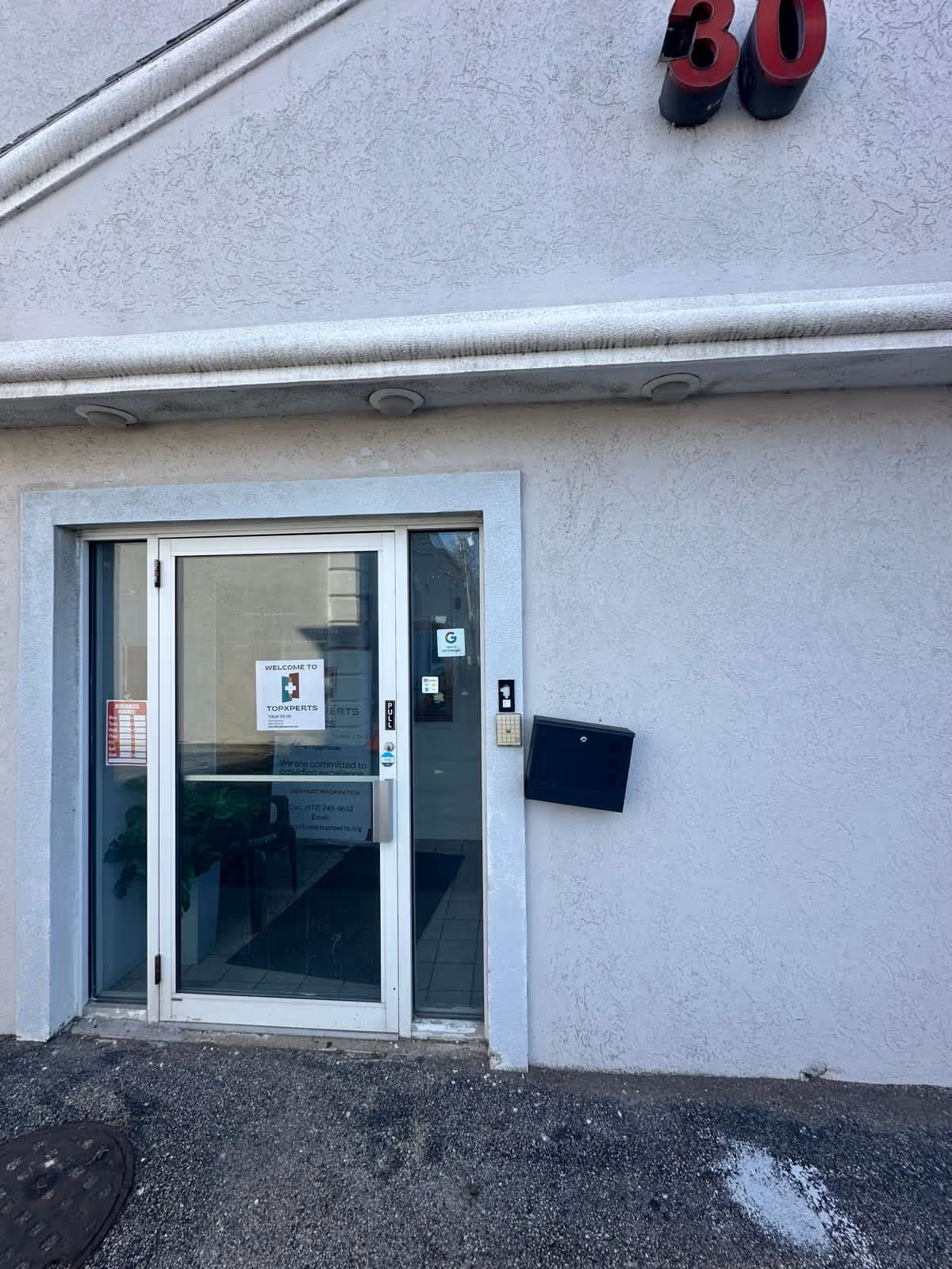 Exterior entrance of a senior care building with glass doors and the number 30