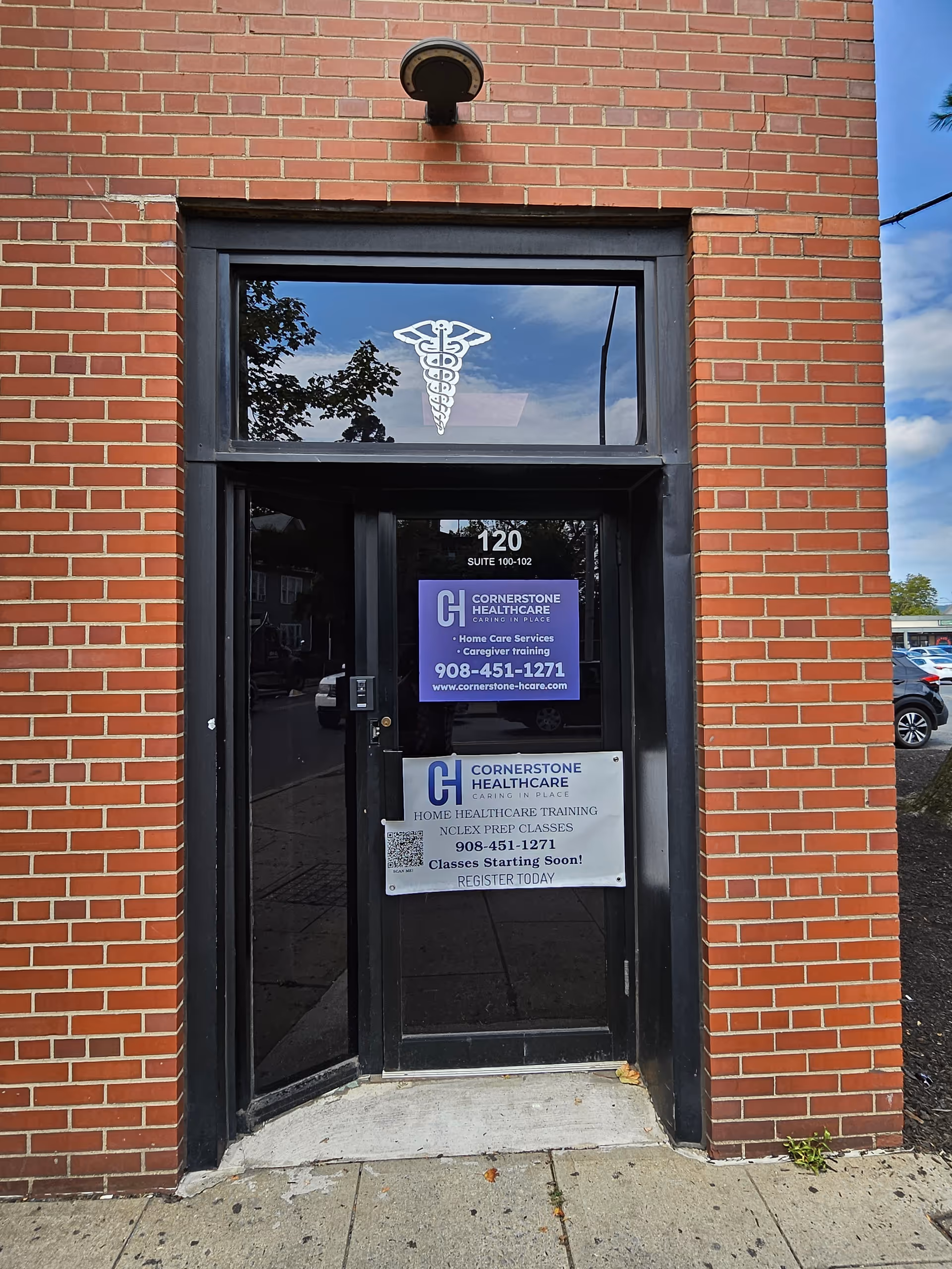 Brick building entrance with a glass door displaying the Cornerstone Healthcare sign and caduceus logo.