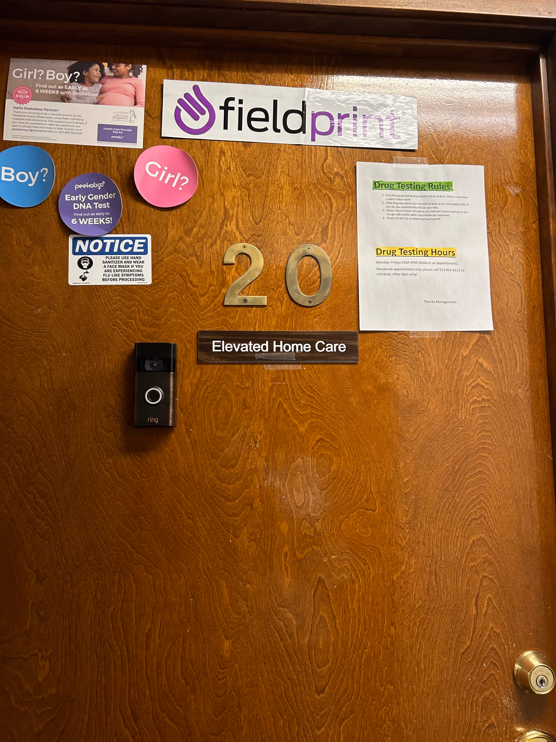 Wooden interior door with large 20 numbers, Elevated Home Care sign, and notices