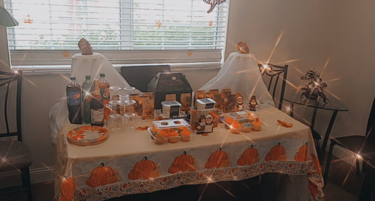 An interior dining table with drinks, snacks, and pumpkin-themed decorations.