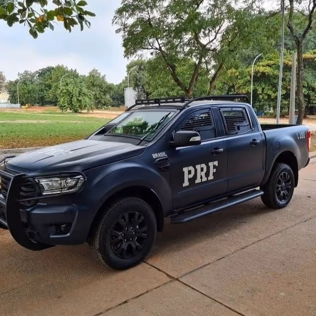 Dark blue PRF police pickup parked on a tree-lined street.