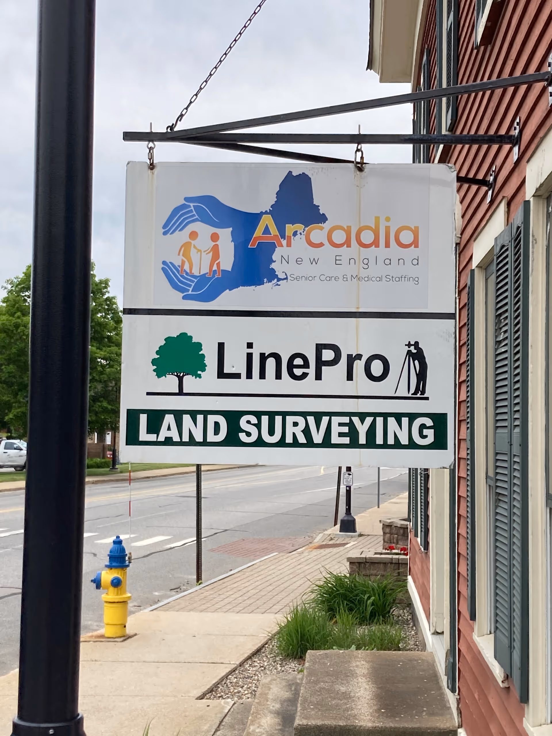 Exterior street view showing Arcadia New England Home Care and LinePro Land Surveying signs.