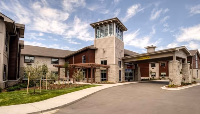 Exterior view of Senior Living at Lafayette showing the entrance, tower, and landscaped grounds.