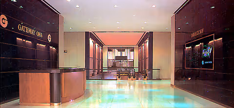 Wide corridor with a reception desk on the left and seating down the hallway.